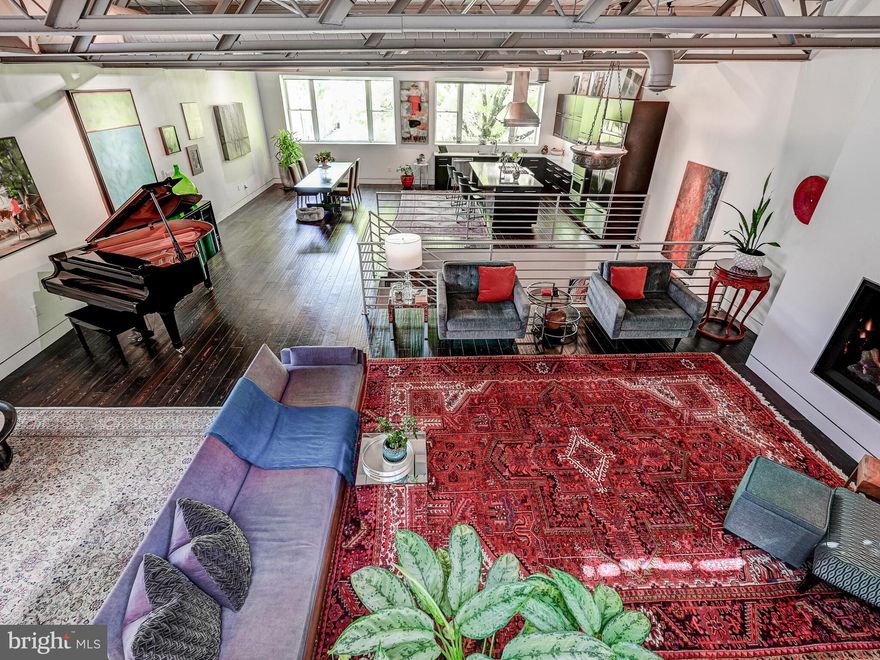 This 4,420 sq ft modern loft invites you to relax and entertain. Originally two row-houses that were converted into a social club in the early 1950's, the building was gutted to the studs in 2010 to create a wide and inviting 4 four bedroom, 3.5 bath oasis. Enter through the main door on the Chapel Street side of the building. A grand entry foyer, with walk in coat closet, leads to the wide stairwell, open and soaring to the second floor ceiling.  Arrive on the sunny second floor with large north and west facing windows and an open floor plan for the kitchen, dining and living areas. The kitchen has a 9 ft island for dining and cooking on the gas range with an exterior-venting Viking hood. Double Viking wall ovens, a build in drawer microwave and counter-depth, dutch-door stainless steel refrigerator allow multiple chefs to work side by side. Across from the kitchen, the dining space comfortably seats over 20 people for a formal dinner, or 50+ people for cocktails. The living room features room for multiple seating areas and an XL vented gas fireplace. A half bath with a large porthole shaped window and matching round sink is located off the living room. The primary bedroom is on the rear of the second floor of the house. The suite features large walk-through closets and a spa-like bath with soaking tub, separate shower, floating double-sink vanity, water closet and radiant heated floors. The second floor deck is accessible from the primary bedroom and bathroom. Recently updated with Cool Trex decking, this space is flanked by privacy fences and overlooks the lower level patio garden. Three additional bedrooms are located on the ground floor. Two bedrooms share a full hall bath. These bedrooms open onto a private,  30X15 patio with dappled willows and other mature potted plantings. A side gate gives access to the yard, which is surrounded by a 8 ft privacy fence with decorative bamboo facing. Walk through the gallery hall toward the front of the house where the fourth bedroom spans the 28' width of the first floor. This 500 sq ft space has a private entrance, full bath, kitchenette, large walk-in closet and laundry hook ups. This space has been a bedroom, photo studio, art gallery, studio apartment, Airbnb, and most recently a retail shop. Use your imagination. Centered on the Chapel Street side of the building is the 27'x21' (567 sq ft) two car garage, which is heated and has a level two charging station. From the living room, take the stairs to the roof top deck with 365 degree city views of all your favorite Baltimore landmarks. This is a walkers paradise, with the waterfront promenade just two blocks away, grocery shopping at Whole Foods or Safeway within a mile, dozens of restaurants and shops just steps away, and quick access to all the acres of green space at Patterson Park or the petite Thames Street Park with a fenced tot lot.