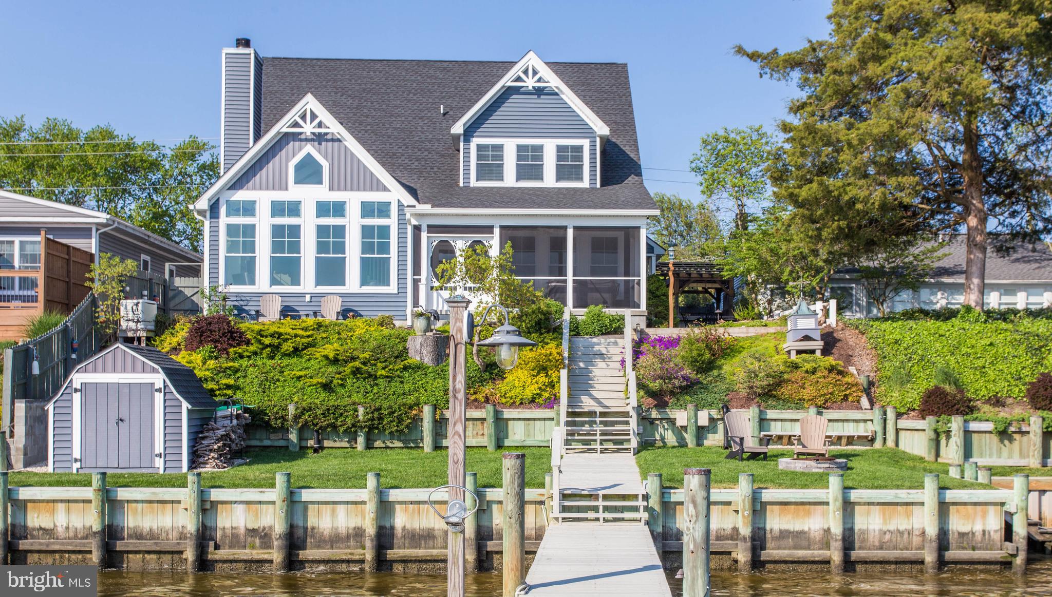 Enjoy an exclusive waterfront lifestyle in this custom-built home situated directly on the Indian River Bay. Enjoy the convenience of your boat docked right at your back door. Take the boat to numerous waterfront restaurants in the area. Why fight traffic on the road when you can rent a boat slip at the Indian River Inlet, take your boat from your door, dock and walk to the state park beach with ease. The 113 foot pier completed in 2020 is complete with a sundeck, lounge area, 2 power boat lifts and jet ski lifts. Enjoy your days fishing and crabbing from the comfort of your own pier with front row seating to daily sunsets . Steps into the bay allow for safe access to kayak and paddleboard too. This wonderful three bedroom, two full and one- half bath home boasts an open floor plan featuring luxury vinyl plank flooring throughout, two-story ceilings in the great room with a shiplap accent wall, built- in bookshelves, a gas fireplace with stone surround, and expansive views of the Indian River Bay. The spacious kitchen and adjoining dining area offer quartz countertops, beautiful custom cabinetry and a large center island for all to congregate. Enjoy your morning coffee from the waterfront screen porch and calmly end your day watching the spectacular sunsets in the salt water spa/jacuzzi. Multiple outdoor seating areas are great for entertaining and feature paver walkways, a fish pond, landscape lighting, and a firepit area. This home has a first floor owner's suite with a shiplap accent wall, a beautiful walk-in shower and custom closet system. Upstairs has two spacious bedrooms with a shared bathroom. Additionally, there is room for easy expansion of an additional 628 square feet that is currently a walk-in storage area on the second floor. Multiple conveniences include a private outdoor shower, Generac whole house generator, a tankless hot water heater and a whole house water filtration system. You can easily call this private oasis home and enjoy a waterfront lifestyle all your own! Located 17 miles from the Cape Henlopen State Park in Lewes and 15 miles to the Rehoboth Beach boardwalk. Easily boat to your favorite destinations and arrive by water without the wait in road traffic.