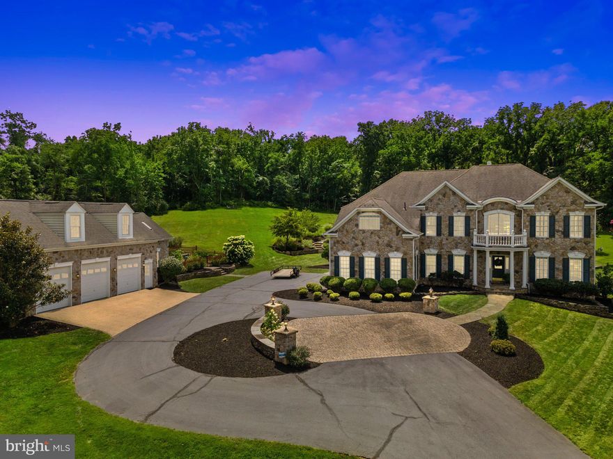 BRAND NEW PRICE - SCHEDULE TO SEE THIS HOME TODAY!!!  Welcome Home to 40243 Featherbed Lane, Lovettsville, VA 20180, a stunning estate home offering luxurious living in a serene, private and secluded setting. This magnificent property, built in 2002, features five bedrooms, four full bathrooms, one half bathroom, and 6,854 square feet of meticulously designed living space. Perfectly nestled on 10.12 acres, the home boasts a six-car garage—three attached and three detached, with added storage—ensuring ample space for vehicles and hobbies.

As you approach this stunning home and property upon driving up the private paved road that leads you through two elegant stone columns and up to a circular driveway, setting the stage for this captivating property. Inside, the grand two-story foyer greets you with hardwood flooring and a striking staircase, seamlessly blending elegance with thoughtful design. The main level includes a formal dining room with a butler’s pantry, a spacious chef’s kitchen equipped with gas cooking, stainless steel appliances, a warming drawer, custom cabinetry, granite countertops, and a center island with a bar area. Next to the kitchen, the sunroom offers access to the outdoor deck and patio, while the coffered ceiling living room with a gas stone fireplace provides a cozy yet sophisticated space. Added features on this level include a large office, half bathroom, laundry room with cabinetry, mudroom, and access to the attached 3-car garage.

The upper level is highlighted by the owner’s primary suite, complete with a tray-lit ceiling, a three-sided gas stone fireplace, and a sitting room. The ensuite offers dual vanities, an oversized Jacuzzi tub, a custom shower, two large walk-in closets with built-in shelving, and a central island with extra drawers. Three more bedrooms share this level, one with its own private bathroom and walk-in closet, while two others connect via a Jack-and-Jill bathroom with natural light tunnels. A versatile bonus room with built-in shelving adds flexibility for use as an added bedroom, game room, or office.

The fully finished lower level expands the home’s functionality, featuring a bedroom with backyard access, a full bathroom, a gym, a second kitchen, a recreation room with coffered ceilings and a gas stone fireplace, a cedar closet, and a wine storage room capable of holding 480 bottles of your favorite wine and utility / storage room. 

Outdoor living is equally impressive, with multiple patios, a large deck, a chicken coop, and a detached three-car garage that includes a workshop and an unfinished second level, perfect for potential use as an in-law suite or guest quarters. The 10-acre property highlights manicured lawns, wooded areas, panoramic views, stone walls, and walkways, creating a perfect blend of natural beauty and functional space.

Conveniently located in Western Loudoun County, this home is near shopping, dining, wineries, breweries, and commuter routes, offering easy access to Northern Virginia, Maryland, Washington, D.C., and Dulles International Airport, just 32 miles away. This exceptional property is a rare opportunity to own a custom-built estate that combines luxury, privacy, and convenience.