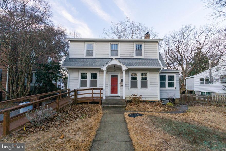 Nestled into the quiet neighborhood of University Park, with mature trees, stunning architecture, and proximity to shops and the art district, sits this charming colonial with a center walkway that leads to the arched gable portico.  Inside the original hardwood floors are warm and inviting. The fireplace, the built in book shelves, and the glass french doors leading to a small library/den add to the charm of the main room.  To the left is the formal dining room, with plenty of light for cheerful dinners at the table.  The kitchen has been enlarged and updated with calm neutral colors, and plenty of windows to let in sunlight.  There is a space for a breakfast table, or perhaps a bakers table.  Beyond the kitchen is a main level, fully equipped bedroom/bathroom combination with a roll in shower and other amenities that would suit any accessibility needs.   The sliding door opens to a small deck landing and overlooks the rear yard.  
Upstairs the wood floors continue, with three bedrooms and a full bathroom.  Loved and with lots of years left in it is the large classic era bathroom with white tile and cast iron tub.  
The basement is partially finished, including a bedroom and bathroom combination.  The remainder of the basement level is used for storage, laundry, and mechanicals.  The door leading to the rear yard makes the basement accessible separately from the main level.  
The yard and garage are a great size for relaxing, gardening, and even hosting gatherings.  The space is sprinkled with just enough sun coming through the trees to keep you warm but not over heated.  The full sun areas are great for small gardens.  
This home has been loved for roughly 40 years by the current owner and is now ready to be loved again by the next homeowner.  If you want a beautiful classic University Park gem, this is it!!!