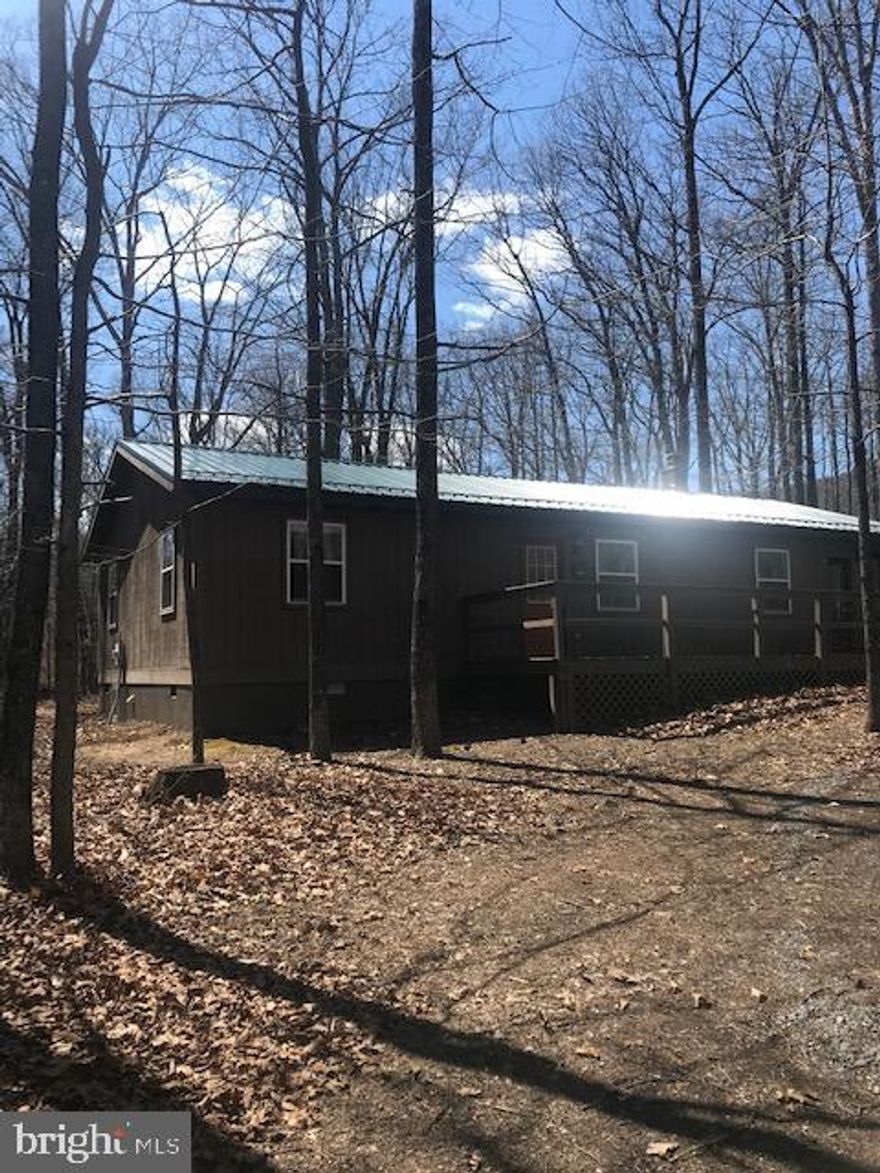 Peaceful and Secluded 1120 sq ft ranch home on  6.42 wooded acres.  2 BR, 1 BA  offers rest and relaxation for your family. Open airy feeling w/cathedral ceilings, kitchen, living room with sliding glass doors to screened in porch. Newer flooring throughout. NEW metal Roof. Enjoy the community benefits of deeded access to the Cacapon River including picnic areas and bath house. You'll enjoy fishing, swimming and tubing. River Ridge is a gated community. This house  can be yours for $155,000. 00.  Taxes will be re-assessed for both lots.