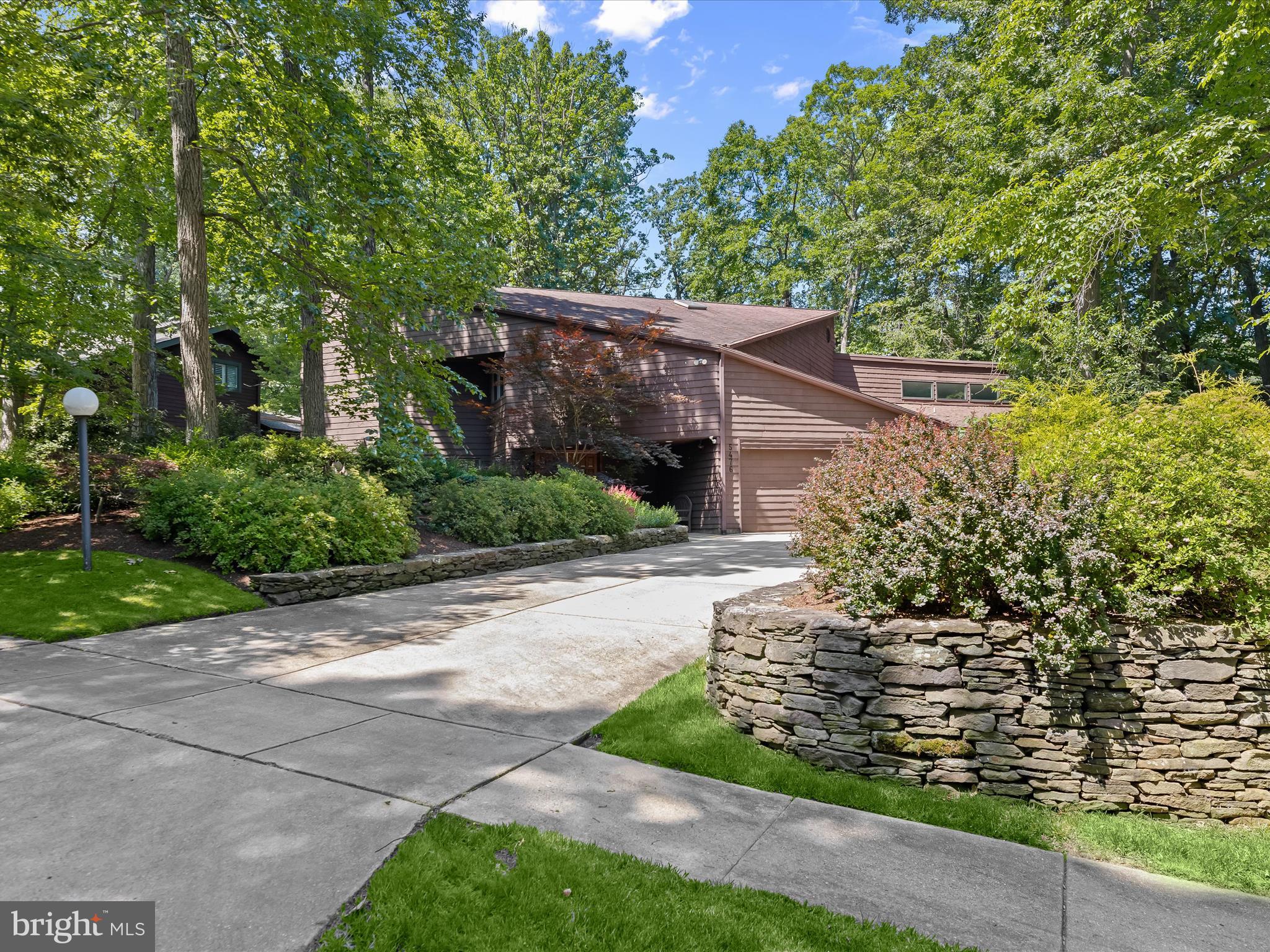 Stunning 6-bedroom, 4.5-bath Craig Stewart build home nestled in the serene, wooded, and highly sought-after Village of Long Reach community. Boasting over 5,000 sq. ft. of living space, this home offers a bright, airy floor plan with soaring vaulted ceilings and walls of windows that flood the interiors with natural light and frame scenic wooded views. Updates include the HVAC, kitchen, powder room, refinished siding, and also equipped with a whole house vacuum system. A bluestone walkway leads to the original waffle double-door entry, opening into a gorgeous open-concept interior with hardwood flooring and design inspired color palette. The living room features a wood-burning see-through fireplace shared with the family room that showcases a 2-story wall of windows offering picturesque views and heated flooring. The dining room flows into the gourmet kitchen, updated with quartz countertops, a natural stone backsplash with a sleek, modern flair, stainless steel appliances that include a Sub-Zero refrigerator and induction cooktop and a dual-entry walk-through pantry and laundry combo, accessible through pocket doors on each side. The main-level primary suite addition showcases a glass tile accent wall, original built-in maple wood workstation, and a luxurious bath with custom maple cabinetry, dual vanity, an oversized shower, and a spacious walk-in closet outfitted with a premium organization system. Upstairs, abundant natural light pours in from the two-story ceiling and overlooks the family room below, and includes a second primary bedroom suite offering a private balcony, a loft sitting area, en suite bath, and walk-in closet. Two additional bedrooms share a dual-entry full bath, and a fourth bedroom completes the level. The finished lower level provides a recreation room, a bedroom, full bath, and ample storage. Outdoors, enjoy an expansive ground-level deck surrounded by mature trees and lush landscaping with an in-ground sprinkler system. 2-car oversized garage and expansive driveway. Perfectly located near major commuter routes, with abundant shopping, dining, and entertainment just minutes away.