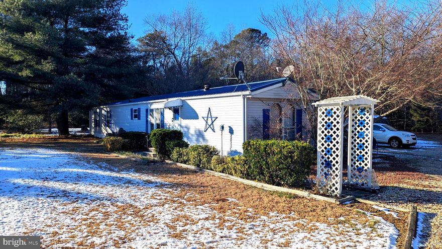 Private and peaceful 2BR/2BA manufactured home on a full acre, offering exceptional space and privacy. An approximately 30x30 metal building provides the perfect setup for a mechanic, workshop, or garage with room for tools, equipment, and projects, plus an additional shed for extra storage. The property also features a summer kitchen with a rear storage lean-to, ideal for entertaining or utility use. Backed by thick forest and lined with cypress trees, this home offers outstanding seclusion and a quiet setting with endless possibilities.