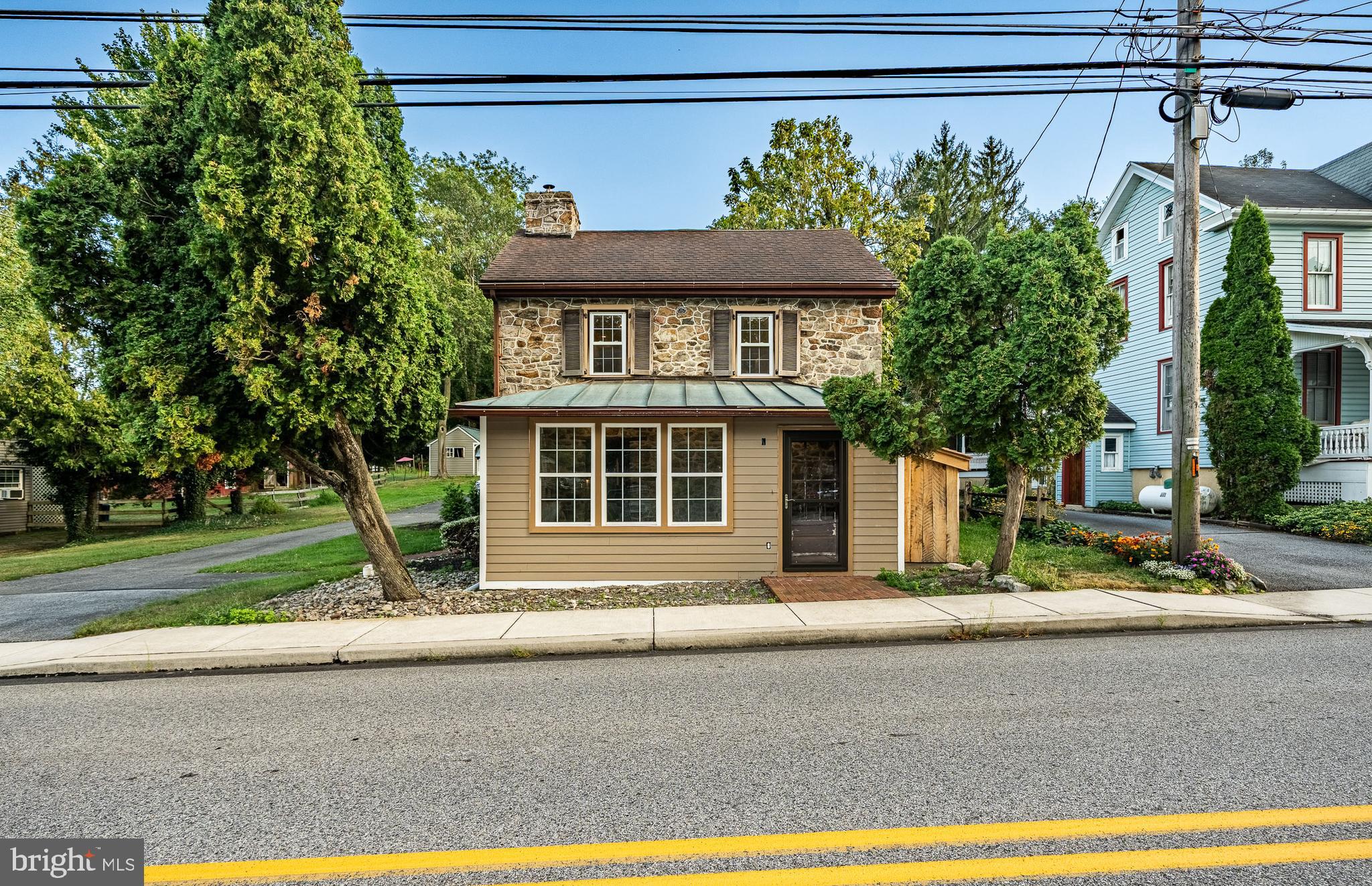 Welcome home to 59 E Main Street located in the heart of Elverson. This three bedroom, three bathroom historical home is situated on a half acre lot and has beautiful features throughout. Charming features inside the home include exposed wooden beams and stone walls. The focal point of the spacious living room is the original wood burning fireplace. The living room is currently in the process of being renovated and restored. Through the stone archway is the dining room and eat-in kitchen. Large windows surround the dining room and kitchen providing warm natural light to stream inside the home. The kitchen features rich cabinetry, ceramic tile backsplash, stainless steel appliances, and an island with a breakfast bar. Off of the kitchen is a full bathroom that is also in the process of being cosmetically updated. There is also a large sunroom that is being renovated. Upstairs are three bedrooms and two full bathrooms. The primary bedroom is getting cosmetic updates and the en-suite bathroom is also being finished. The laundry is located on the second floor. The attic has plenty of storage space but also has the ability to be finished. Outside, the expansive backyard provides plenty of space for gathering and entertaining. Additional updates to the home include new wiring, new plumbing, and new windows. This property is zoned residential commercial so someone could make it into a shop or store. Located a half mile from three golf courses and in close proximity to the Pennsylvania Turnpike. Don’t miss this charming home on your tour!