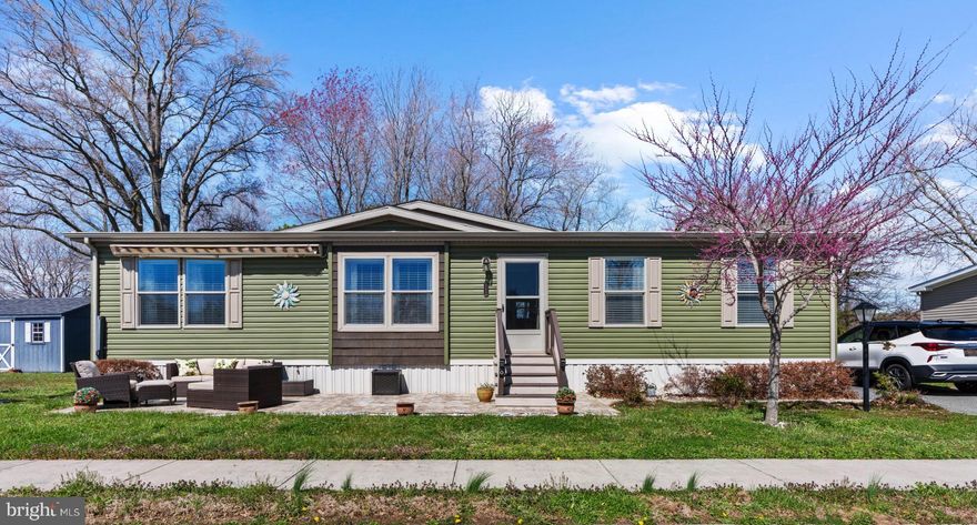 Come see this beautiful, manufactured home in the desirable 55+ section of Ridgewood Manor—showcasing true showroom condition with exceptional attention to detail throughout! Offering 3 bedrooms, 2 full baths, and 1,404 sq ft of luxury living, this home is perfectly situated on a premium  privacy lot backing to a tree-lined setting. This exceptional property delivers the perfect blend of privacy, style, and convenience, enhanced by upgraded siding and striking curb appeal.

Inside, this sought-after Commodore Astro Elite open-concept floor plan is thoughtfully designed for both everyday living and effortless entertaining. The spacious layout seamlessly connects the living room, dining area, and kitchen into one bright, airy space, while maintaining privacy with a smartly separated bedroom design. Luxury interior finishes shine throughout, including 8-foot flat ceilings, smooth-painted drywall, elegant crown molding throughout, deep window sills, extra windows for added natural light, a new front door, and numerous other upgrades.

The chef-inspired kitchen is the heart of the home, featuring Evermore custom 42” cabinetry, an oversized chef’s island with bar seating, a deep stainless steel farmhouse sink, built-in microwave, ceramic tile backsplash, and a stunning designer walk-in pantry with a sliding barn door—perfectly blending style and function. Stainless steel appliances, including the refrigerator, are all included.

The spacious primary suite offers a private retreat with a large walk-in closet and a wonderful bath complete with a double bowl vanity and a huge  ceramic tiled walk-in shower. Two additional bedrooms and a second full bath provide flexible space for guests, hobbies, or a home office. A separate laundry/mud room with a secondary side entry adds convenience, and the washer and dryer are included.

Built with efficiency in mind, this home features a Super Energy Package and is Energy Star certified, providing year-round comfort and cost savings. Outside, enjoy upgraded exterior siding, a low-maintenance front patio with a retractable awning, a custom 14x10 matching storage shed, and a three-car paved parking pad. Other fine features include  new plush carpeting, recessed lighting, exterior outlets and electric.  
The 55+ section of Ridgewood Manor, known as Ridgewood Pointe, is a secluded enclave of just 42 homes. This home  is ideally situated on the private side of Indigo Circle.  Lot rent is $779 monthly.  Enjoy refined, low-maintenance living at its finest—schedule your visit today!