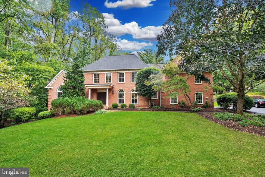 This all-brick Colonial home enjoys a large corner lot on a peaceful cul-de-sac abutting parkland. As you step into the grand two-story marble foyer with a sweeping “Cinderella” staircase, you enter a world of elegance and functionality. The expansive living room, featuring a 12-foot tray ceiling, sets the tone for sophisticated gatherings. The embassy-sized dining room provides space for large dinners. More casual meals may be enjoyed in the  breakfast area of the gourmet kitchen. The adjoining two-story family room, with its stunning stone gas fireplace, offers a cozy spot for relaxation. Upstairs, unwind in the luxurious primary suite with a spa bath and dual walk-in closets, providing a private retreat. Additional bedrooms offer comfort and privacy, with a guest room featuring an ensuite bath. Plus, a nook overlooking the family room creates a versatile space for an office or lounge area. The lower level enhances your lifestyle with a recreation room featuring a wood-burning fireplace and wet bar—perfect for large social gatherings or viewing a game or movie. An exercise room and additional bedroom add functionality.
Outdoors, a deck provides al fresco space amidst professionally landscaped grounds. A two car garage provides ample parking and storage. Nearby amenities include: Lahey Lost Valley Park, Meadowlark Botanical Gardens, and Wolf Trap for recreation and entertainment; shopping in nearby Vienna or Tyson’s Corner; and major transit routes including the DC Beltway and the Dulles Access Road.
