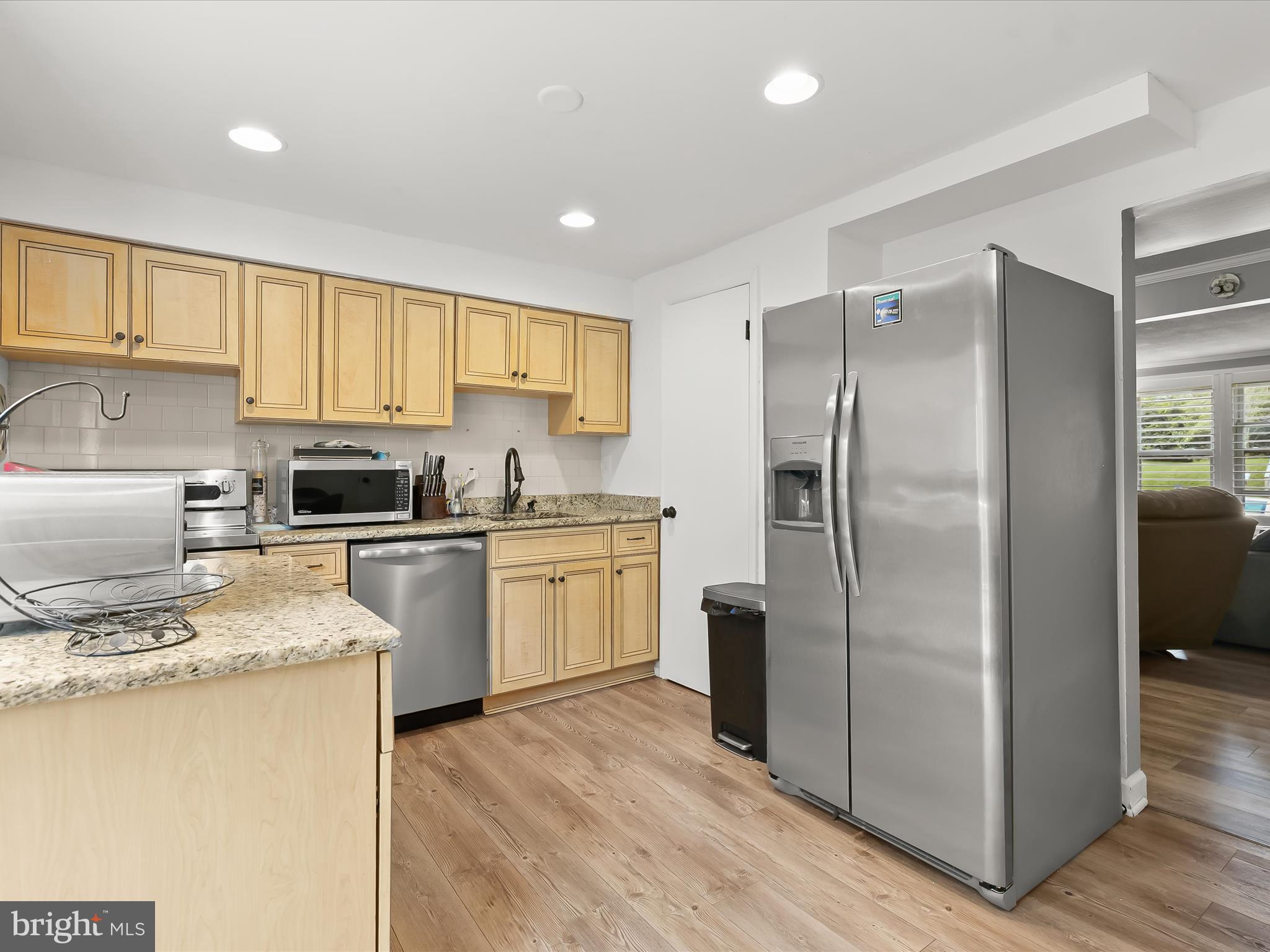 Welcome home to this three bedroom, two and a half bathroom home, quietly tucked away on a cul-de-sac backing to trees. A welcoming front living room highlights luxury vinyl plank flooring and a neutral palette that flows seamlessly throughout. The updated eat-in kitchen showcases granite counters, a tile backsplash, stainless steel appliances, and an island, with the adjoining dining area opening through sliding glass doors to a composite deck overlooking the woods. Upstairs, the primary bedroom offers a private bathroom with a walk-in shower, while two additional bedrooms share a full bathroom with a tub shower. The finished lower level provides a spacious recreation room with a wood-burning fireplace and direct access to the backyard. A utility room with laundry and storage adds convenience, while the expansive backyard features a patio and ample space for outdoor activities.  FHA assumable mortgage with a 3.125% interest rate subject to buyer qualification.