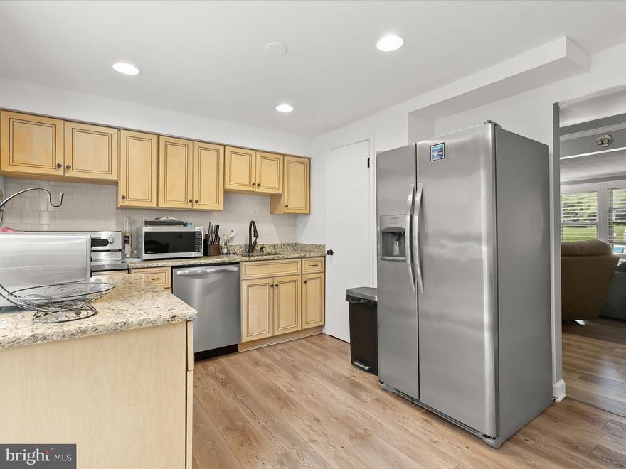 Welcome home to this three bedroom, two and a half bathroom home, quietly tucked away on a cul-de-sac backing to trees. A welcoming front living room highlights luxury vinyl plank flooring and a neutral palette that flows seamlessly throughout. The updated eat-in kitchen showcases granite counters, a tile backsplash, stainless steel appliances, and an island, with the adjoining dining area opening through sliding glass doors to a composite deck overlooking the woods. Upstairs, the primary bedroom offers a private bathroom with a walk-in shower, while two additional bedrooms share a full bathroom with a tub shower. The finished lower level provides a spacious recreation room with a wood-burning fireplace and direct access to the backyard. A utility room with laundry and storage adds convenience, while the expansive backyard features a patio and ample space for outdoor activities.  FHA assumable mortgage with a 3.125% interest rate subject to buyer qualification.