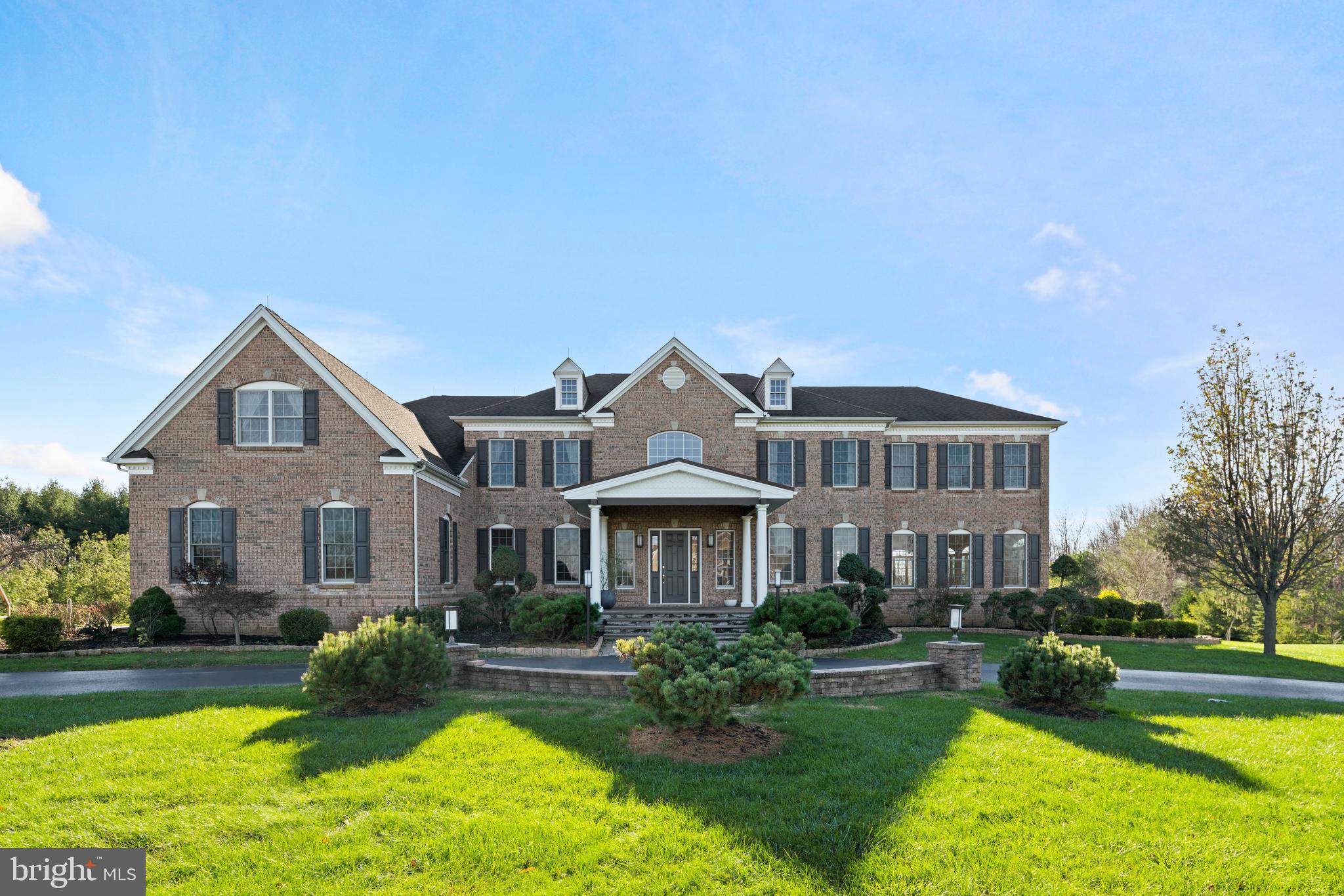 Welcome to 136 Jane Chapman Drive, an elegant Georgian style estate home located in the prestigious community of Chapmans Corner. Enter through the large, open foyer and you are greeted by a gorgeous wrought iron butterfly staircase that invites you into this remarkable open floor plan. Flanked on both sides are the dining room and formal living room with double crown molding and detailed millwork. The living room is open to the sun-drenched conservatory with its walls of windows. The 2-story gathering room with a coffered ceiling will leave you impressed by all the natural light as well as a floor to ceiling stone gas fireplace. The gourmet kitchen is bright and spacious and ready for entertaining. Its open floor concept is perfect for everyday living or hosting parties or holidays. Featuring a remarkable center island, Viking cooktop, stainless steel appliances and granite countertops along with an abundance of cabinetry and sunny breakfast area with convenient access to the rear yard. Working from home is easy in the large office with French doors that can be closed for privacy. Completing the 1st floor is a half bath and an oversized mud room/laundry room with cabinetry and access to the garage. Head upstairs by either staircase to the hallway overlooking the foyer and gathering room. Your new private getaway will surely be in the main suite. Entering through double doors, framed by architectural columns, it includes a spacious sitting area and fantastic closet space. The spa-like bathroom includes modern oversized his and her vanities, his and her water closets, a Jacuzzi tub and an oversized shower. It also boasts a bonus room that could also double as a dream closet, gym or another home office. There are 2 other generously sized bedrooms which have en-suite baths and the other 2 feature a Jack and Jill bathroom. The vast walk-out lower level can easily be finished into wonderful additional living space. Hardwood floors grace the entire house. Additional home amenities are a governor’s driveway, 3 car garage and a water filtration system. The home backs to open space and is just minutes away from Newtown Boro with its shopping and dining. Conveniently located to NYC, Philadelphia and Princeton. Council Rock School District. Don’t let this one get away.