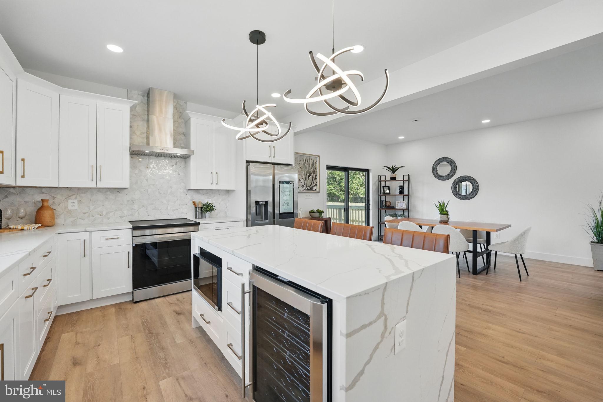 Price of $874,750 includes all the upgrades you see, PLUS A 2-CAR GARAGE! Luxury NEW home within walking distance of all the charm, dining, shops and entertainment of Old Town Manassas ... and even the VRE for easy commuting! The home offers a flowing, open concept, main level living with abundant natural light, premium finishes and designer lighting! Stunning waterfall quartz countertops, immense center island, custom cabinetry, and upgraded stainless steel appliances to include a built-in wine cooler, allows for a chef-inspired experience! The laundry room, with its beautiful "utility sink" houses a full-size washer and dryer, supplied by the builder. The very spacious den on the main level is truly a fifth bedroom, boasting wonderful closet space and could easily be used as a second living area! A gorgeous full bath is conveniently located off the great room, so if the need arose for a main level bedroom and bath, its there! Luxurious upper-level primary suite with a spa-like shower and walk-in closet is a must-see! The three other upstairs bedrooms, ALL come with their own private bathrooms! Expansive deck, great for outdoor dining and entertaining, extra parking on the long concrete driveway in addition to the detached garage and a privacy fence adds to the perfect blend of modern living, convenience and outdoor space! No HOA and economical City of Manassas utilities!