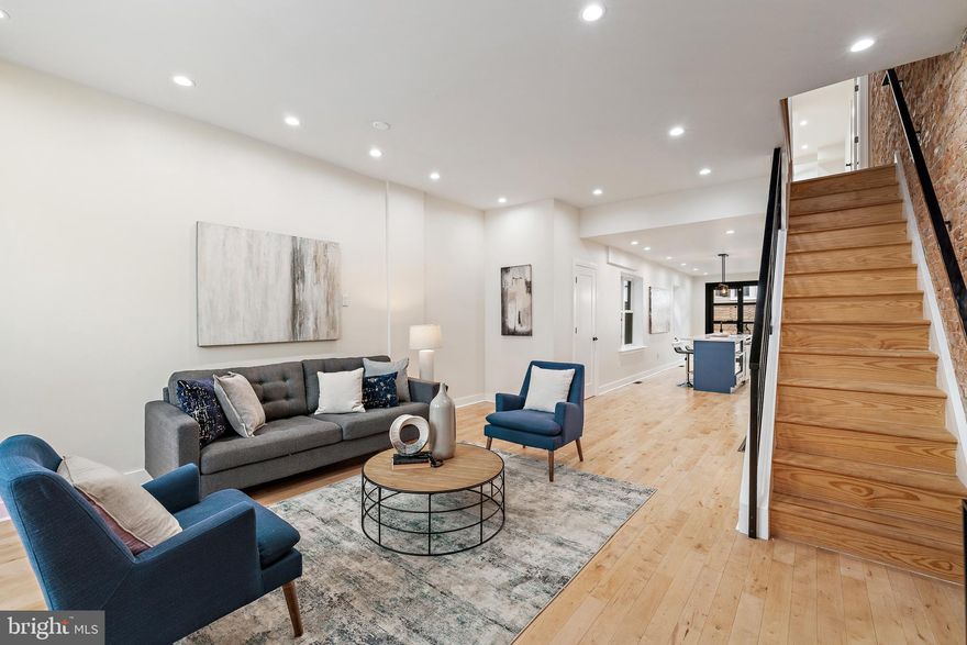 Standing out from the average reno, 1316 N 29th St has been expertly rehabbed with luxury finishes and distinctive design that mirrors the pages of an architectural magazine. This 3-story home is set on an extra-deep lot, offering 4 bedrooms + a study, 2.5 bathrooms, a huge private deck, and a prime location a block from Girard Ave in sought-after Brewerytown. The exterior prominently displays a classic red brick facade with black accents. The open main level welcomes you inside with a bright and airy feel, aided by high ceilings and neutral hardwood floors. An exposed brick wall anchors the living room, where a pair of towering windows allow great natural light. Across from the wrought-iron staircase, the powder room features unique tile and lighting. The highlight of the home is undoubtedly the show stopping kitchen, fitted with contemporary flat-front cabinetry, quartz counters, top-of-the-line matte white GE Cafe appliances, a textured subway tile backsplash, and a massive island with seating and a second sink. Off the dining area, a wall of windows overlooks the expansive rear deck, providing the perfect outdoor space to create a garden oasis for hosting barbecues with friends and family or relaxing alone with a glass of wine. Up on the second level, two bright, spacious bedrooms with hardwood floors and ceiling fans are at the front. A large third bedroom with bay windows connects to the all-white hall bathroom that has a floating double vanity. The hotel-like primary suite encompasses the entire third level. There's a huge sunlit bedroom with tall windows, a terrace, two custom closets, and a study that could act as a dressing room, an office, or a fitness space. Completing the level is a luxurious two-sided bathroom with dual vanities, a glass-enclosed shower, a soaking tub, and a pocket door, allowing simultaneous use. The home also has tons of storage space and laundry in the clean, dry basement. In addition to everything inside, 1316 N 29th St's fantastic location earns a Walk Score of 82! Steps away, Girard Ave is lined with popular restaurants, friendly shops, and markets, plus Athletic Square Park and a community co-op are within a few blocks. There's also easy access to University City, The Philadelphia Zoo, Kelly Drive, The Art Museum, Fairmount Park, public transit, and I-76. Schedule your showing today!