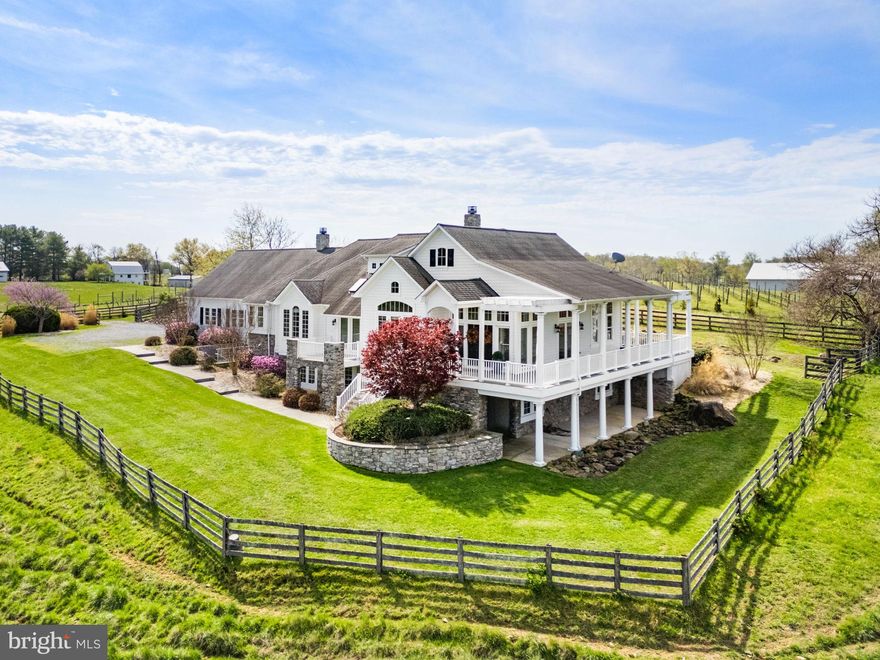 Nestled on over 14 private acres along 1,236 feet of Beaver Dam Creek frontage, this exceptional custom Chadsworth estate offers refined country living just minutes from Round Hill and western Loudoun amenities. This property blends timeless craftsmanship, expansive living spaces, and breathtaking natural surroundings in a premier rural setting with no HOA.

A stately stone and HardiPlank exterior welcomes you to a thoughtfully designed residence featuring nearly 5,700 finished square feet across two levels, with additional unfinished space reflected in tax records. The main level offers true one-level living, anchored by a luxurious primary suite with hardwood floors, tray ceiling, spa-inspired bath with jetted tub, walk-in shower, his and her reading lights and generous walk-in closet (one of eleven total closets within the property). Additional main-level spaces include a formal foyer, sitting room, private office with two sets of French doors, den with built-ins, formal dining room with skylights and balcony access, and a warm living room with double-sided electric fireplace.

The country-style kitchen is both functional and inviting, featuring granite countertops, center island, double wall ovens, ENERGY STAR stainless appliances, skylights, and abundant cabinetry. The adjoining breakfast room includes a second electric fireplace and views of the surrounding landscape. A large mudroom and main-level laundry add everyday convenience.

The fully finished walkout lower level offers remarkable flexibility with four additional bedrooms, multiple Jack-and-Jill baths, a recreation room, bonus room, and den—ideal for guests, multi-generational living, or home-based workspaces. Each bedroom offers generous proportions, walk-in closets, and access to full baths.

Architectural details throughout include vaulted, tray, and two-story ceilings, hardwood flooring, chair rail and wainscoting, recessed lighting, skylights, and expansive windows that frame pastoral and creek views. The home is equipped with zoned HVAC, propane-owned heating system, humidifier, dehumidifier, air filtration system, and energy-efficient windows and appliances.

Outdoors, the property offers endless possibilities—gardening, recreation, or simply enjoying the serenity of creekside living. The attached side-entry two-car garage complements the home’s thoughtful layout, while the rural AR-1 zoning provides flexibility and multiple of potential use options.  The 30'x50' metal barn/workshop with electric coupled with the two stall run-in at the back of the property offer significant possibilities for future use. 

Conveniently located near Route 7, historic Round Hill, wineries, and outdoor recreation, and served by Round Hill Elementary, Harmony Middle, and Woodgrove High School, this rare offering combines acreage, water frontage, and luxury living in one of Loudoun County’s most scenic settings.

Note: aerial photography property lines on photos are an approximate estimation.