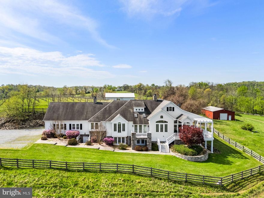 Nestled on over 14 private acres along 1,236 feet of Beaver Dam Creek frontage, this exceptional custom Chadsworth estate offers refined country living just minutes from Round Hill and western Loudoun amenities. This property blends timeless craftsmanship, expansive living spaces, and breathtaking natural surroundings in a premier rural setting with no HOA.

A stately stone and HardiPlank exterior welcomes you to a thoughtfully designed residence featuring nearly 5,700 finished square feet across two levels, with additional unfinished space reflected in tax records. The main level offers true one-level living, anchored by a luxurious primary suite with hardwood floors, tray ceiling, spa-inspired bath with jetted tub, walk-in shower, his and her reading lights and generous walk-in closet (one of eleven total closets within the property). Additional main-level spaces include a formal foyer, sitting room, private office with two sets of French doors, den with built-ins, formal dining room with skylights and balcony access, and a warm living room with double-sided electric fireplace.

The country-style kitchen is both functional and inviting, featuring granite countertops, center island, double wall ovens, ENERGY STAR stainless appliances, skylights, and abundant cabinetry. The adjoining breakfast room includes a second electric fireplace and views of the surrounding landscape. A large mudroom and main-level laundry add everyday convenience.

The fully finished walkout lower level offers remarkable flexibility with four additional bedrooms, multiple Jack-and-Jill baths, a recreation room, bonus room, and den—ideal for guests, multi-generational living, or home-based workspaces. Each bedroom offers generous proportions, walk-in closets, and access to full baths.

Architectural details throughout include vaulted, tray, and two-story ceilings, hardwood flooring, chair rail and wainscoting, recessed lighting, skylights, and expansive windows that frame pastoral and creek views. The home is equipped with zoned HVAC, propane-owned heating system, humidifier, dehumidifier, air filtration system, and energy-efficient windows and appliances.

Outdoors, the property offers endless possibilities—gardening, recreation, or simply enjoying the serenity of creekside living. The attached side-entry two-car garage complements the home’s thoughtful layout, while the rural AR-1 zoning provides flexibility and multiple of potential use options.  The 30'x50' metal barn/workshop with electric coupled with the two stall run-in at the back of the property offer significant possibilities for future use. 

Conveniently located near Route 7, historic Round Hill, wineries, and outdoor recreation, and served by Round Hill Elementary, Harmony Middle, and Woodgrove High School, this rare offering combines acreage, water frontage, and luxury living in one of Loudoun County’s most scenic settings.

Note: aerial photography property lines on photos are an approximate estimation.