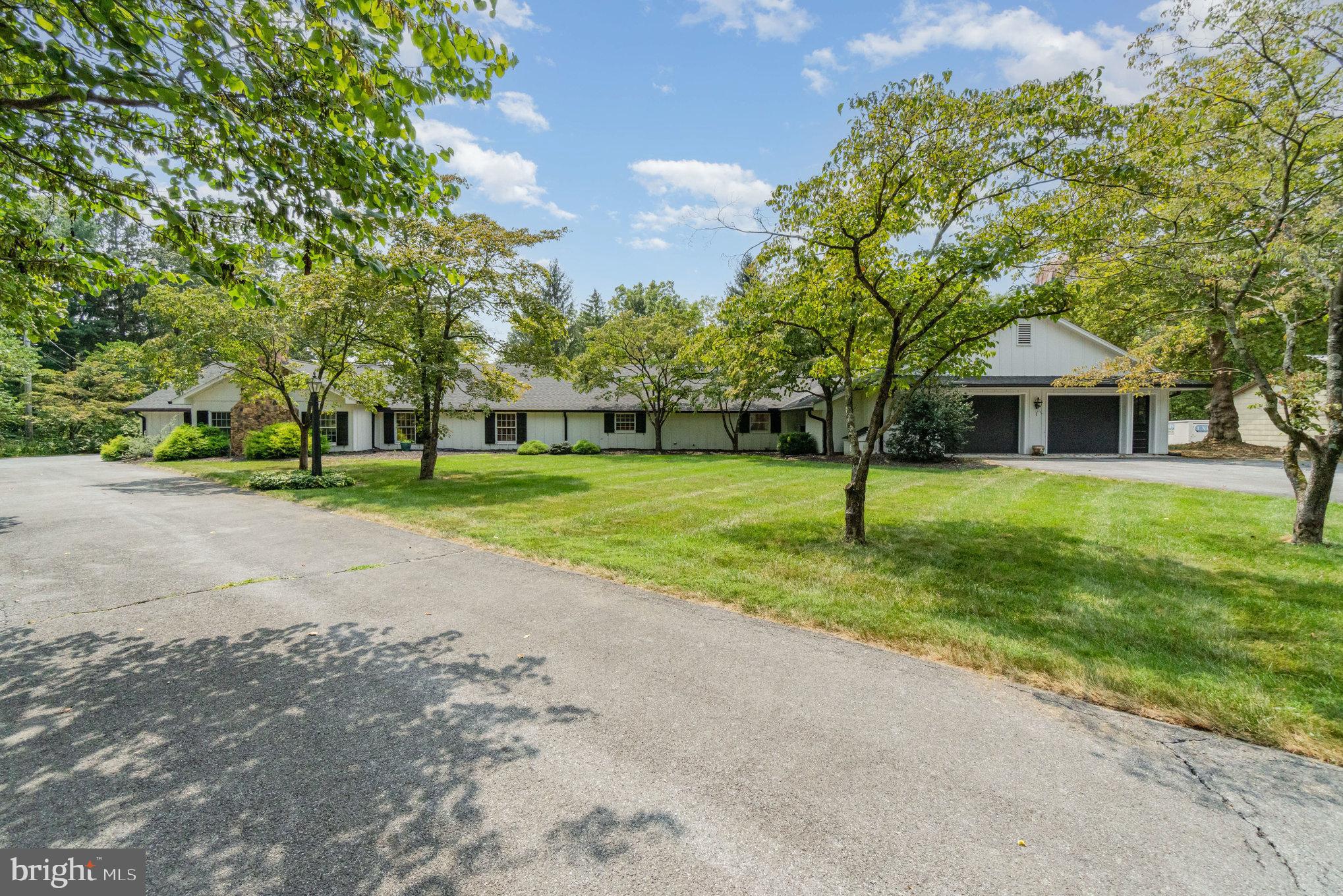 An extraordinary opportunity awaits with this private 12-acre estate nestled in the heart of Silver Spring Township, within the highly sought-after Cumberland Valley School District. Rarely does a property of this caliber become available—featuring two separate homes, a 2,500+ sq. ft. garage, a silo, and endless possibilities for multigenerational living, rental income, a home-based business, or future development. This exceptional offering provides unmatched versatility—live in one residence and lease the other, accommodate extended family, or capitalize on the potential to subdivide and expand. With its ideal location, expansive acreage, and extraordinary range of uses, this is a once-in-a-lifetime opportunity to own a truly remarkable and adaptable estate.
95 Pleasant Grove Rd - Sitting on nearly 9 acres, the fully renovated main home is a sprawling ranch with over 2,700 sq. ft. of thoughtfully designed living space. The home features 3 to 4 bedrooms and 2 full baths. Upon entering, you are welcomed by a cozy sitting area that doubles as an ideal home office. The heart of the home is a bright and airy chef’s kitchen adorned with white cabinetry, quartz countertops, a coordinating backsplash, and a sloped shed dormer ceiling lined with windows to bring in an abundance of natural light. This kitchen opens to a spacious family room complete with a wood-burning fireplace, while a formal dining room provides a perfect setting for gatherings and special occasions. From the kitchen, access the private rear patio and pergola—an ideal space for relaxing or entertaining guests.
The primary suite is a true retreat, offering soaring ceilings, ample natural light, and a spa-like bathroom featuring a walk-in shower, garden tub, and double bowl vanities. Two additional bedrooms and an updated hall bath provide comfort for family or guests, while a versatile fourth bedroom, office, or flex room offers access to the rear yard. A well-appointed mudroom/laundry area connects directly to the oversized two-car garage. Beyond the home the property includes a large detached garage/workshop of approximately 2,500 square feet.
97 Pleasant Grove Rd - The second home, located on an adjacent 3.5-acre parcel, is a nearly 2,000 sq. ft. ranch ready for your personal vision. Whether you choose to renovate it for rental income, use it for extended family, or reimagine it as part of your dream estate, this home offers endless opportunity.