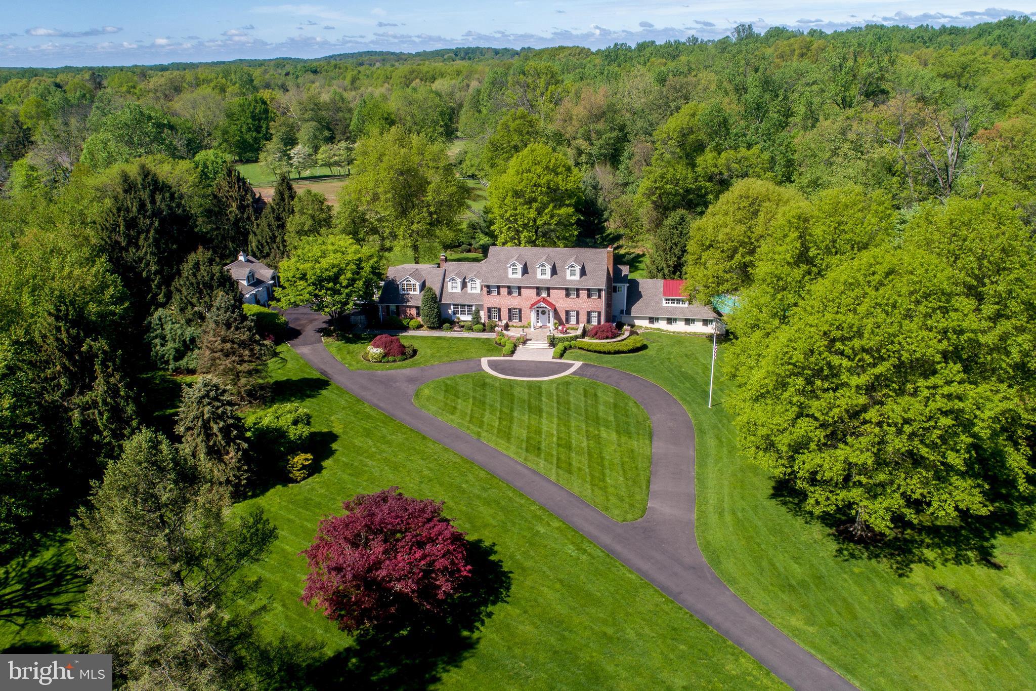 The stunning setting, graced with a long driveway approach past a pond & charming gazebo, will take your breath away as you arrive at this outstanding home and property! Privately positioned far from a quiet country road & offered for the first time in over 30 years, this gracious 5 bedroom, 3.2 bath custom home has been expanded, updated and beautifully maintained over the years by its present owners. The handsome center hall brick and frame home boasts handsome mill work and built-in cabinetry, gleaming wood and pegged floors, extensive use of custom Pella clad windows and French doors, and care and attention to detail throughout! A circular driveway approach, herringbone brick walk ways, and a blue stone & brick terrace lead to the front door. Inside, the entrance foyer with turned staircase is flanked by a living room with brick gas fireplace, and generous dining room. Adjoining the living room is a home office outfitted with custom pine cabinetry, a handy Butler's Pantry with built-ins, granite counters, bar sink & and under counter Subzero refrig. The core of the home is the custom kitchen, light & sun-filled , leading in all directions to numerous living areas. The inviting kitchen showcases white cabinetry, granite counters, a center island, pantry, desk, and newer Viking, Kitchen Aid, Asko and Subzero appliances. A serving/eating bar w/granite counter and doorway provide direct access to the Family Room, appointed w/ a raised hearth Mercer tile fireplace, built-ins, & coffered ceiling. Just steps away is an inviting Breakfast Room w/window surround, and Vermont Castings Stove (propane). Also, a step-down solarium w/vaulted bead board ceiling, truss detailing, window & French door surround, & four new solar-powered skylights, opening to a covered terrace w/new pergola. The first floor is also home to the newer expansive in-law quarters complete w/built-ins, generous closets, new carpeting, & a full bath w/stall shower w/frameless door. A rear hallway leads to the outdoors, and a back staircase allows easy access to the upstairs bedrooms. A newer wing with radiant heat includes a large laundry room with built-ins, utility sink, washer & two dryers, a back staircase to the Main Bedroom suite, and easy access to a lower tier Great/Media room w/powder room, and a walk-out to a hot tub and sports court! The Great Room is outfitted with custom cabinetry & a computer desk area, a media section w/TV, and windows for natural light - an ideal room to just hang out! The 2nd floor main bedroom suite retreat is lush with wall to wall carpeting, handsome molding, and a newer travertine marble full bath with shower, steeping tub, vanity with two sinks, 2 walk-in closets & more! 3 addt'l bedrooms and a bonus room, all unique & beautifully-appointed, share an updated hallway bath w/steeping tub, shower, glass vessel sinkas, and truss framed skylights. The part-finished basement/playroom has bead board detailing, a fun stage for dancing & shows, a 2nd kitchen, cedar and storage closets, & a large mechanical room with built-in shelving. The handsome detached brick 3-car carriage-style garage with dormers is appointed w/carriage doors(new openers), its own entrance foyer & steps to a floored 2nd floor-great potential for finishing! Additional features include 11 zones of heat (oil hot water and radiant),a new boiler (2018), new hardie plank siding, new dimensional shingle roof (main house, garage, & gazebo (2018), new solar-powered skylights- (7) (2018), newer Pella French doors and windows, new hot water heaters-(2) 2018), a portable generator- the list goes on! And the total peace of mind stemming from a home that has truly been loved and maintained. Lush with shade trees, pines, protective woods and scenic views in every direction, this exceptional property, in a highly-desired area of Buckingham, is simply a rare find!