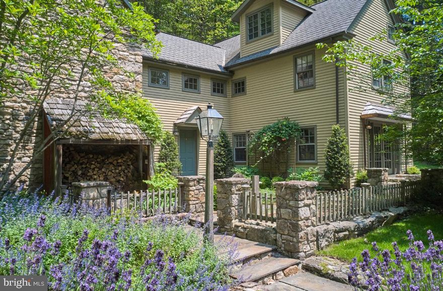 With roots dating back to the 1700s, "The Beacham House" is a magical haven banked into seven hillside acres on sought after Honey Hollow Road within Bucks County, PA.   This special estate exudes storybook allure, with preserved architectural materials, dramatic stone walls, rich hardwoods, and hand-hewn exposed beams that bring warmth and character throughout. The property consists of a circa 1820 stone house, a detached carriage house with full gym, a newly installed gunite lap pool, extensive hardscaping, mature landscaping and a hot tub built into stone boulders. The meticulous preservation of this estate reflects an unwavering commitment to maintain the integrity of the property, a dedication that has borne fruit in the form of a breathtaking sanctuary. The designer of this estate has ensured that every nuance within this oasis embodies the highest quality materials, and anything that was reconfigured was done so using natural components from the surrounding environment. Within the main residence, a charming kitchen boasts custom-made cabinetry, soapstone countertops, an integrated butcher block, and top-tier appliances featuring a SubZero refrigerator and a six-burner Wolf range with vented hood, all atop radiant heated flooring.  A welcoming breakfast nook, opening onto an elegant stone patio via French doors, overlooks the lavender gardens, thus extending the interior living space into the natural surroundings. Italian tile detailing and wide-plank hardwood floors enhance both homes, while Pella architectural windows allow abundant natural light to flood the interiors. A stone adorned wood-burning stove is the focal point of the living room and emanates quintessential Bucks County charm. Just beyond is an inviting sitting area—ideal for leisurely reading, relaxation, or an office space. Ascend the staircase, skillfully repurposed by hand using reclaimed wood from the estate, to discover the Owner's Suite. This suite showcases exposed beams, a fireplace, a full bathroom with a glass shower, soaking tub, and a hidden staircase—adding to the home’s unique character. Two additional bedrooms with ample closet spaces, a full hallway bathroom, and a spacious fully finished attic on the third floor complete the upstairs accommodation. The darling carriage house, having undergone a complete renovation, features a deluxe kitchen with soapstone countertops, bar seating, a refrigerator, oven, and a Bosch dishwasher. Exposed stone embellishes the walls of the living room, and French doors open up to a private patio offering serene poolside and property views. The upper level includes a bedroom, a full bathroom, walk-in closet, and direct access to a private gym. The exterior of the property is equally captivating with its heated lap pool w/automatic retractable cover, a four-person hot tub, a new shed, chicken coop, and newly installed split rail fencing, encompassing a picturesque landscape that includes secluded woodland and grassy areas. The carriage house also showcases a two-car garage with handcrafted Spanish Cedar doors featuring specially crafted hardware cognizant of the time period.  The exceptional characteristics of this estate are highlighted by a half-century lifespan cedar roof on the primary residence,  new metal roofing and copper drain systems on both homes, a centralized vacuum system, water purification and softening installations, and a recently installed septic system. Occupying an idyllic location equidistant to the heart of Bucks Counties best small towns,  and nearby all major commuter routes, the sanctuary known as "The Beacham House" presents a remarkable fusion of preserved craftsmanship, endearing allure, and everlasting enchantment. (*ALL contents within the property are also available for purchase*)