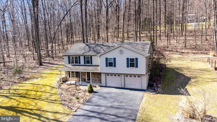 Bi Level style offering single level living. A separate living space on the first floor with a bedroom, kitchenette and full bath. The second level offers a formal dining room, kitchen with an island and an open living area. 3 bedrooms and 2 full baths complete the space. 
A 2 level deck out the sliding glass doors lead to a lovely, wooded area accessible from the master bedroom as well.
The attached oversized 2 car garage offers built in cabinets and a music system. Ample space for a workshop for the home handyman.