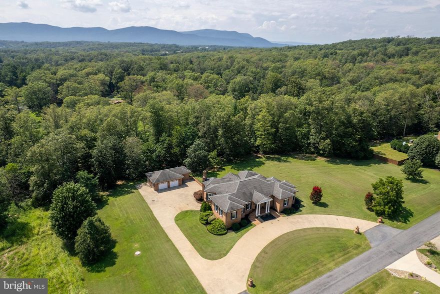 Elegance, Quality, Timeless design & Exceptional Mountain views abound at 177 Hatcher Drive, Front Royal, VA.  Discover the perfect blend of comfort and elegance in this stunning 4-bedroom, 4-bathroom ranch-style home nestled in the desirable Highland Park community. Custom-built all-brick sprawling floor plan boasts a spacious 4,032 sq. ft. of finished living space, ideal for relaxation, privacy, and entertaining. Step inside to find a warm and inviting interior featuring hardwood floors, crown moldings, and built-ins that enhance the home’s charm. The gourmet kitchen, complete with an island and New appliances, is a culinary enthusiast's dream. Enjoy cozy evenings in the family room off the kitchen, by the cozy fireplace. The main floor laundry and entry-level bedrooms add convenience to your daily routine. Venture downstairs to a partially finished basement with ample space for customization, including a walkout level that leads to your private outdoor oasis. The heated indoor spa and personal pool invite you to indulge in year-round relaxation. Set on a generous 2-acre lot, the property offers a serene backdrop with panoramic mountain views and lush landscaping. Enjoy the tranquility of nature as the lot backs to trees, providing privacy and a peaceful retreat. The circular driveway and multiple garage spaces ensure ample parking for guests. With easy access to commuter lots and the airport, this home is ideally situated for both convenience and leisure—minutes to the Shenandoah River for boating, floating, fishing, or swimming.  Fall hikes along nearby Skyline Drive and breathtaking views of fall foliage will be a favorite pastime as you enjoy a hot cup of coffee, relaxing inside or on the terrace.  Don’t miss the opportunity to make this exquisite property your own, where every detail has been designed for your comfort and enjoyment.