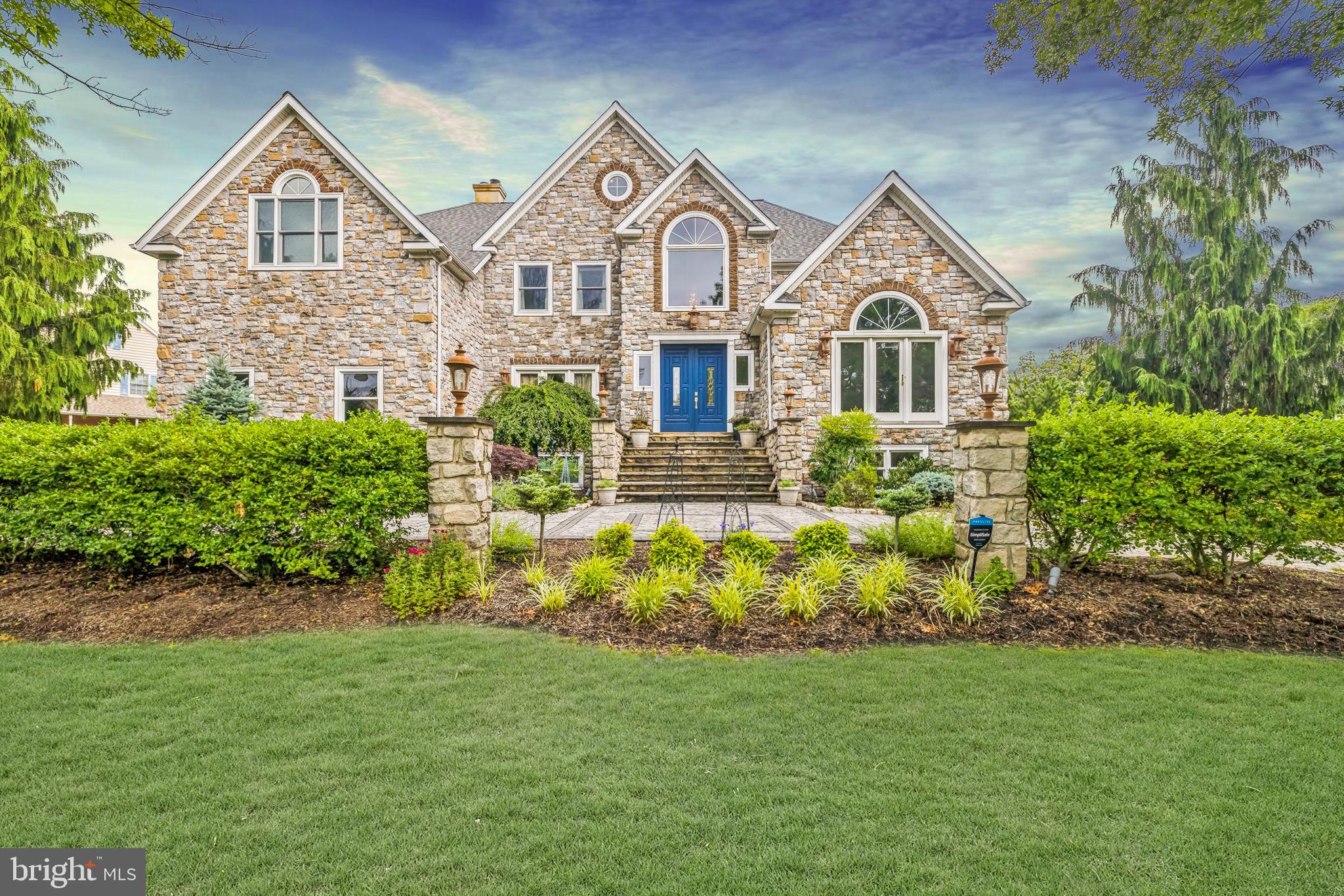 Welcome to an exquisite retreat at 170 Brochant Circle, Blue Bell, PA. This sophisticated home, boasting approximately 6,500 square feet of luxurious living space, is perfectly situated on a sprawling 27,434 square-foot lot. Featuring five generously-sized bedrooms and seven bathrooms—comprising five full baths and two half baths—it offers an abundance of space and comfort for all.
Step into the heart of elegance, where expansive living areas flow effortlessly with high ceilings, multiple fireplaces, and exquisite finishes throughout. The gourmet kitchen is a chef’s delight, featuring premium Thermador appliances, a spacious island adorned with leathered granite, and a butler’s pantry. Adding to its charm, the kitchen includes a soapstone sink that complements the sophisticated design. The elegant touch of travertine floors extends into the mudroom and laundry room, adding timeless sophistication. A coffee bar with matching leathered granite enhances both functionality and style, perfect for starting your day.
The library/den exudes warmth and refinement with custom maple-paneled walls, a vaulted maple coffered ceiling, and is equipped with Hunter Douglas Solar shades for optimal light control and privacy. A captivating glass-inspired temperature-controlled wine vault stands as an elegant focal point in both the family room and office, featuring solid walnut countertops and shelves, perfect for showcasing your collection to guests. Throughout the home, the primary bedroom, second-floor hallway, and family room are enhanced with hand-scraped Brazilian Cherry floors, adding rich elegance and warmth.
The primary bath boasts bamboo flooring, creating a serene sanctuary, while the Jack and Jill bath features elegant quartzite countertops. All other bathrooms are adorned with granite countertops, ensuring a consistent theme of luxury and durability. The approximately 2,000 square feet of finished basement space offers versatile options for entertainment, relaxation, or a personal gym, all graced with luxury vinyl plank flooring for both style and durability.
Outdoor spaces include manicured gardens and a serene patio covered with 1-inch thick outdoor porcelain pavers, and an inlaid basketball court at the top of the driveway. Discover unparalleled sophistication and a lifestyle of ease in this remarkable Blue Bell estate, where every detail enhances refined living, offering a seamless blend of luxury and comfort.
