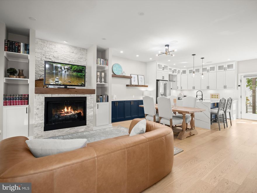 NEW PRICE -  $100K BELOW TAX ASSESSED VALUE! Best location and value in Old Town!  Introducing 603 N Alfred Street, a modern masterpiece in the heart of Old Town Alexandria. Built just three years ago, this exceptional four-level residence offers nearly 2,500 square feet of living space, including four bedrooms and four-and-a-half baths, all designed with comfort and sophistication in mind.
The home’s striking curb appeal continues inside with soaring ceilings, oversized floor-to-ceiling windows, and dramatic western light pouring into the main living areas. A sculptural gas fireplace with a marble surround anchors the living room, while custom built-ins and a sleek credenza add both elegance and function.

The main level is anchored by an open living and dining area that flows seamlessly into the chef’s kitchen. Oversized, floor-to-ceiling windows flood the space with natural light, while a striking marble-wrapped gas fireplace and custom built-ins add a sense of style and warmth. The dining area transitions smoothly into the kitchen, where crisp white cabinetry is paired with Regal Blue accents, quartz countertops, and a waterfall island. Stainless steel GE Café appliances, a microwave drawer, and a farmhouse sink elevate both form and function, making this the perfect setting for entertaining or casual gatherings. A chic powder room, built-in credenza, and integrated Sonos speakers complete the main floor.

Upstairs, two spacious en-suite bedrooms with walk-in closets and spa-like baths occupy the second level. The top floor is dedicated to a spectacular owner’s suite, complete with large walk in closet and spa like master bathroom featuring double sinks, a freestanding soaking tub, oversized custom-tiled shower. Furthermore, the master suite provides direct access to a rare private rooftop terrace offering panoramic views of Old Town and beyond.

The versatile lower level includes a fourth bedroom or flexible family room/home office, a full bath, laundry, storage, and utility space.

A private backyard is equally inviting, featuring a trellis-covered patio, lush green lawn, and a white picket fence that encloses two secured parking spaces with gated access.

Situated in the heart of Old Town’s historic district, this home perfectly balances timeless charm with contemporary luxury. Just blocks from King Street’s boutiques and dining, the waterfront, and both King Street and Braddock Road Metro stations, the location offers unmatched convenience. Easy access to Washington, D.C., The Pentagon, GW Parkway, and major commuter routes make this an extraordinary opportunity to own a nearly new home in one of Alexandria’s most sought-after neighborhoods.