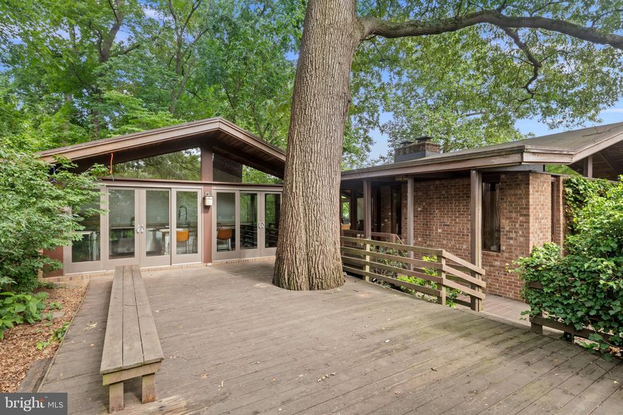 Nestled on a generous, private wooded lot, this mid-century modern home offers timeless design with convenience. The setting feels like a private escape surrounded by both mature trees and saplings. Inside, clean mid-century lines meet contemporary finishes, with an updated kitchen and gorgeous baths. Each spacious bedroom features its own ensuite bath, providing both comfort and privacy for family and guests. While quietly set back from the street, this home is just one mile from the Clarendon Metro station and Clarendon restaurants, shopping and entertainment; less than five miles to DCA; and only 0.4 miles to Spout Run shopping, coffee shop, and even an ice cream shop! Easy access to multiple parks with hiking and access to the Potomac River. Enjoy the serenity of your own wooded retreat, all while being moments away from urban conveniences, major transit, and Washington DC. This home seamlessly blends mid-century character with modern updates and an unbeatable location, offering peaceful seclusion without sacrificing access. The tax records understate the square footage of this spacious residence. The home saw an addition, in which the gourmet kitchen resides. Offering 3,400 square feet of living space, the home provides 3 bedrooms and 3 full bathrooms. Upon arriving, one enters via a walkway connected to a courtyard and large deck. Many additional elements of mid-century design await inside: simple lines, warm refinished hardwood floors,  floor-to-ceiling windows enhancing the connection between the in and out-of-doors, exposed brick and beams, natural room dividers, as well as an open floor plan. This is truly a prime example of mid-century modern meeting 21st century. The dining room and great room see high, vaulted ceilings with exposed beams and a wall of sliding glass doors. These rooms open to the kitchen which enjoys high-end stainless appliances, and its own wall of windows and doors opening to the courtyard and deck, with yard beyond. The living room is just steps away with a brick fireplace, built-ins, and even more windows allowing light to filter in. Before descending to the lower level, let's not forget the primary bedroom. This space offers room for a sitting area and bed area, a walk-in closet, and a lovely bath with walk-in double bench shower/steam room. Let's visit the lower level, renovated only 4 years ago and providing two additional bedrooms suites with oversized windows, ensuite bathrooms, and large built-out walk-in closet; a spacious laundry room with storage; a walk-out level to side yard. This residence is certainly one to see - especially if you're searching for that place to catch your breath but close enough to run to the grocery if you've forgotten that one ingredient. Even better, the light at Lorcom/Spout Run is your one traffic light into DC.