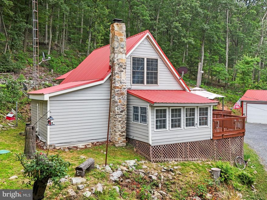 Sweet Dreams Are Made of These – Your Mountain Escape Awaits in Paw Paw, WV. Craving a peaceful retreat from the daily grind? Dreaming of working remotely, surrounded by the sights and sounds of nature? This inviting mountain cabin offers the perfect blend of comfort, seclusion, and practicality. Nestled on 5.02 wooded acres in the scenic Spring Gap Mountain Subdivision, the property features 1,318 square feet of turn-key living space with two bedrooms and one full bathroom. Whether you're planning restful weekend escapes or embracing a full-time mountain lifestyle, this home is designed for simplicity, relaxation, and a strong connection to the outdoors. Inside, a smart and functional layout makes daily living—and hosting guests—effortless. A stackable washer and dryer add convenience, and the upstairs bedroom comes furnished with a queen-size bed, dresser, and bureau. The living room’s couch and loveseat, kitchen table and chairs, along with deck furniture and a barbecue grill, are all included—making your move-in truly seamless. Outside, the oversized two-car detached garage offers a concrete floor and 100-amp electric service—ideal for storage, hobbies, or outdoor gear. A 12'x20' shed with 20-amp service provides even more space for tools or seasonal items. Located in a gated mountain community, the property offers both privacy and peace of mind. Start your mornings with a cup of coffee and panoramic views from the porch, or cozy up indoors and watch the seasons change from the comfort of your cabin. Surrounded by mature trees and natural serenity, this peaceful setting is perfect for both short getaways and long-term living. Less than an hour from Winchester, Virginia, and under two hours from Washington, D.C., the location offers convenient access to city amenities while embracing a slower, more scenic pace of life. With its thoughtful layout, included furnishings, and peaceful wooded setting, this cabin makes it easy to unplug, unwind, and settle into a more intentional way of living. Don’t miss the chance to make this serene West Virginia escape your own—schedule your private tour today and experience the lifestyle you’ve been dreaming about.