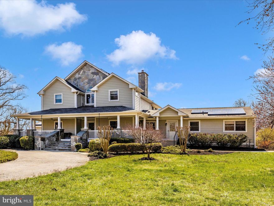 Welcome to Clarksville’s most bucolic estate. Set upon five manicured acres, this home has been diligently remodeled with hand-selected finishes from the custom hand-hewn doors imported from around the world to the bespoke stone columns each crafted by hand lining the wrap around porches.  Inside the home you’ll discover a welcoming two story foyer with a large seeded glass pendant light suspended above gorgeous tile flooring leading to the sunken atrium and large family room.  The atrium and family room feature polished concrete floors with radiant heat, massive imported wood church doors separating the space,  and sliding doors connecting the outdoor covered terrace to the home and creating a spacious entertainment space.  The atrium is home to a display of art thanks to the built-in shelving and abundance of daylight which affords the perfect space to grow ornamental plants.  Abutting the foyer is also one of the home’s offices with the first of many vintage doors and a half bath.  Beyond the foyer is a chef’s kitchen with a stainless steel appliance suite, granite counters, custom oak cabinetry with soft close drawers, and recessed LED lighting.  Additionally, there is an expansive butler pantry which offers ample cabinetry space, a second sink, beverage station complete with an icemaker and stainless refrigerator, and the first of two laundry rooms. Attached to the kitchen is a dining room with hardwood floors and a stone fireplace with woodstove insert and oak mantle flanked by sliding glass doors leading to a trex deck overlooking the saltwater pool.  The first floor is completed with three bedrooms each affording views of the surrounding grounds including the original owner’s suite with ensuite half bath and double closet.  Tucked upstairs; however, is an owner’s suite which spans the entire upper floor and includes space for a king-sized bed, a private balcony, gas fireplace, and yoga enclave.  Enter the owner’s bath and you’ll find an owner’s bath that is sure to rival even the most exclusive resort.  Italian sandstone tiles, a sunken jetted tub, and large walk-in shower with a large shower tower system, imported wooden shuttered windows, and suspended vanities with dual vessel sinks are some of the features found in this space.  A walk-in closet completes the owner’s suite.  The lower level of the home has been designed as a separate living quarters for family, live-in staff, or visiting guests and includes its own kitchenette with electric range, full bath with gorgeous porcelain tile, living room with its own private entrance and separate bedroom.  Connected to this space is an additional laundry room, fitness studio with concrete floor, additional storage, and a safe room with keypad access.  The three car garage completes the home and the third bay features radiant heat in the concrete floor and leads to the changing room for the outdoor shower and swimming pool and also connects to the second office space above the garage.  Stepping into the backyard, the space features abundant areas to entertain.  There is a saltwater swimming pool with Italian glass tile and waterfall feature surrounded by custom hardscape and stone knee walls.  Raised garden beds border the pool and include many perennials.  The custom stone work encloses part of the patio space and creates the perfect shaded haven to keep a close watch on those enjoying the water. Beyond the fenced pool area, is an abundance of grassy yard space perfect for soccer or additional gardening endeavors.  Hoping to raise livestock?  The property boasts its own three stall barn ideal for horses, goats, or highland cows with a massive workshop and outdoor party space.  Behind the barn is the most magical of gardens featuring multiple raised garden beds.. The entire property blooms repeatedly throughout the Spring and Summer thanks to over 100 specimen trees. Hike or ride the WSSC trails from the backyard or go boating at nearby Brighton Dam.