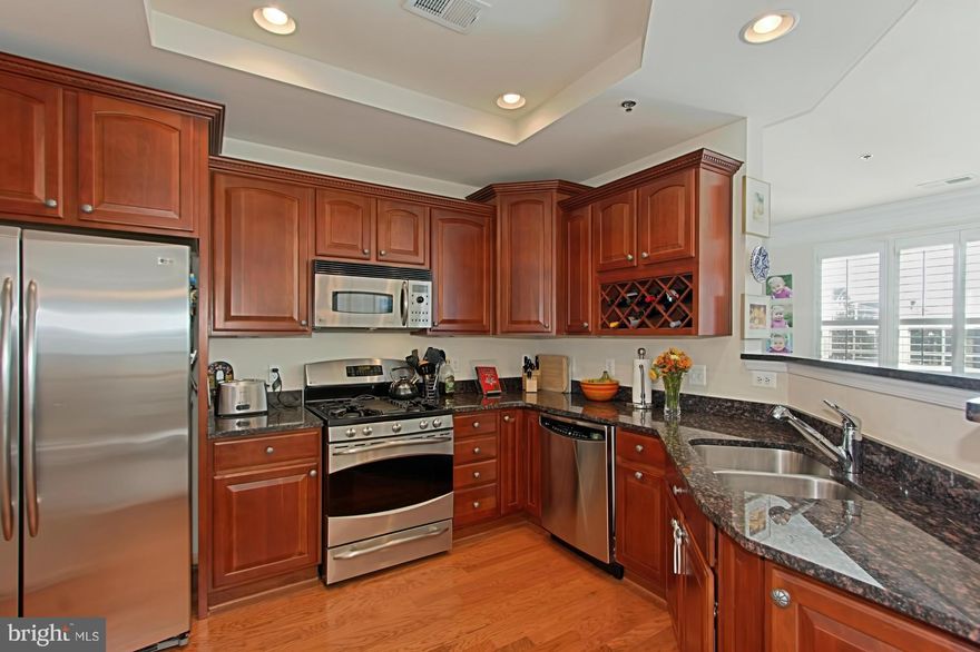 This gorgeous end unit, townhome has everything: 3 BR, 2.5 BA, parking for 2 cars, an open floor plan & distinctive designer details. Enjoy walls of windows w/elegant plantation shutters, separate dining area, wood floors, luxurious MBA. The open kitchen is a chef's delight: upgraded cherry cabinetry, granite counters & top-end SS appl.. Easy commute. Great shopping & dining nearby.FHA Approved!