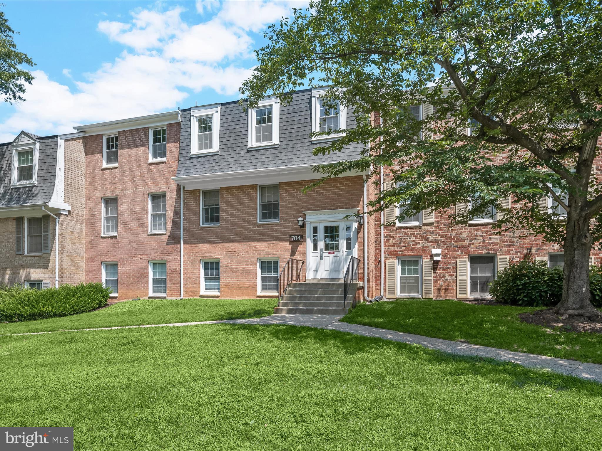 Welcome home to this two bedroom, two full bathroom condo offering comfort and convenience in the heart of Gaithersburg. Freshly painted in a light, neutral palette, the interior is move-in ready and filled with natural light. A spacious living room opens to a private balcony through oversized sliding glass doors with beautiful views of the common grounds for a peaceful setting. A charming brick accent wall adds character to the dining room, and the adjacent kitchen has gas cooking. Down the hall, the primary bedroom has an ensuite bathroom that features a walk-in shower. A second bedroom and full bathroom with a tub shower complete the unit. One assigned parking spot is included, along with access to community amenities including a clubhouse, outdoor pool, sports courts, playgrounds, and more. Monthly condo fees conveniently cover all utilities, and nearby parks provide even more opportunities to enjoy the outdoors. With I-270, Shady Grove Metro, and countless shops and restaurants less than 10 minutes away, this location is hard to beat. Some images have been virtually staged.