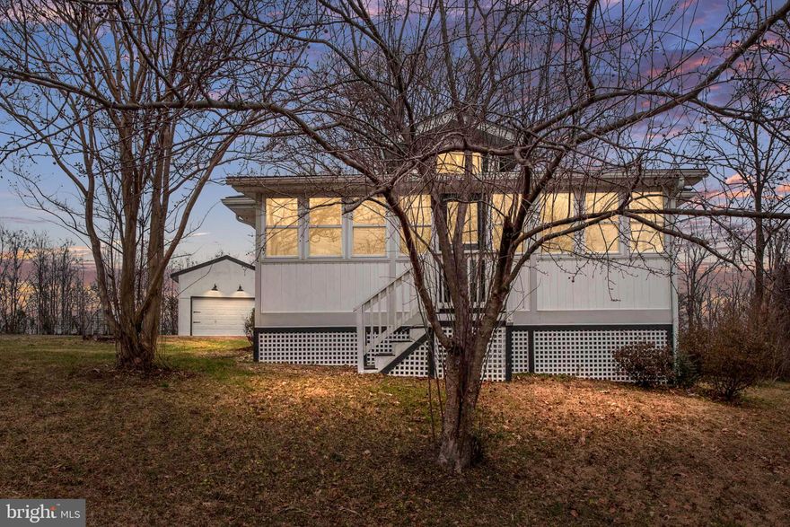 Experience the timeless charm of a 1930s ranch style residence with modern updates, conveniently located just minutes away from the waterfront and the new town center of Potomac Shores and future VRE Station. This unique property, boasting the allure of yesteryear, sits on an expansive plot of nearly an acre with the added advantage of no HOA.
Renovated in 2019, this residence features two bedrooms, two baths, an enclosed porch, and a deck overlooking picturesque trees. The one-and-a-half-story garage is an additional bonus, providing both functionality, storage and convenience. 
Step into an open and inviting Kitchen and Dining Space, illuminated by natural light streaming through sliding doors that lead to the deck and a large bay window. The kitchen is the heart of this home, equipped with stainless steel appliances installed in 2019 and adorned with bright white cabinets. A laundry area, complete with a washer/dryer (2019) and a new water heater (2023), adds practicality to this space. The entryway boasts a designated area for storage or a small office, showcasing the thoughtful design of the home.  Easy-care vinyl flooring seamlessly connects the various spaces, creating a cohesive and low-maintenance living environment.
Throughout the property, updated lighting enhances the ambiance, contributing to the overall modern aesthetic. The two bathrooms, both renovated in 2019, feature contemporary fixtures, with one offering a shower and the other a tub/shower combination. An  open family/living area seamlessly leads to a three-season porch, offering a tranquil retreat.
Enjoy seasonal views of the Jack Nicklaus Golf Course and a convenient stroll to the water, all while being just a short drive away from the upcoming Potomac Shores town center. This residence offers the perfect blend of quiet country living and modern convenience, making it an ideal place to call home. Possibility of being able to assume a VA  2.75% loan.