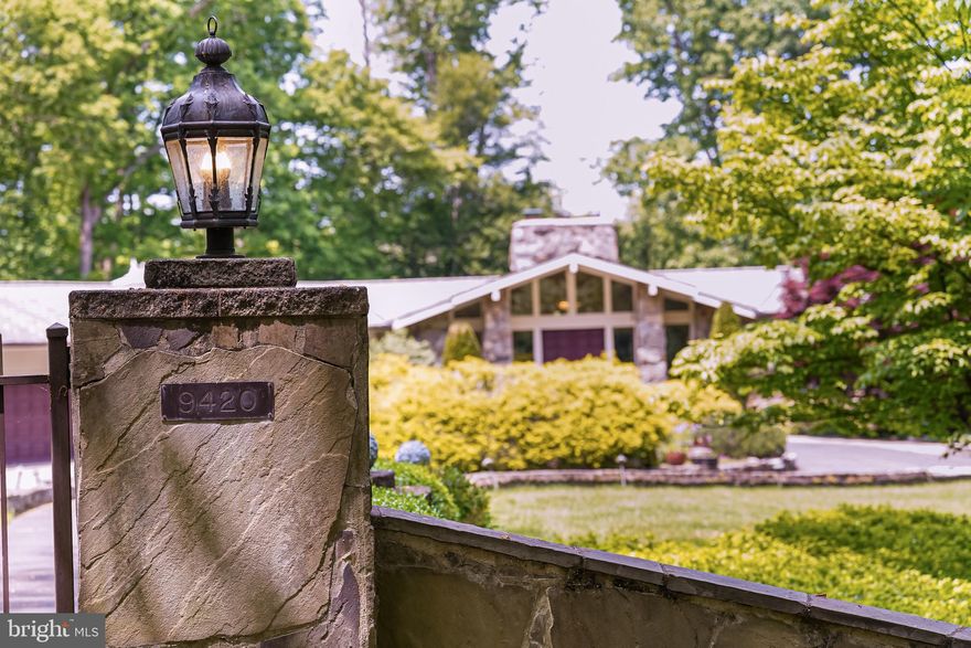One-of-a-kind builder’s custom home on over five wooded acres of serene privacy and natural beauty within walking distance to the Potomac River and Riverbend Park. Tucked away at the end of Piscataway Ln, 9420 is a secluded oasis behind a gated entrance and circular driveway highlighted by a copper fountain. Stone walls and paths around four-season gardens welcome you into the dramatic foyer flanked by full stone pillars and cathedral ceiling. Imagine meals or beverages on one of the three decks or expansive pebble patio with an avian symphony and splashing fountains to entertain and sooth. Indulge your inner Top Chef with the professional grade Viking, Sub-Zero, & Bosch appliances and European cabinetry. True indoor/outdoor flow between the kitchen/sunroom/dining room/main deck. Dining or entertaining indoors is a treat with a twelve-seat quartz countertop island & bar overhang, baker’s bar & beverage bar. The kitchen opens fully to a glass sunroom providing a front row seat to the splendor of the changing seasons. Formal dining room features sputnik designer lighting and Trompe-l’oeil painted walls. The real surprise lies behind the massive Aspen-style solid fieldstone fireplace when the 2-story glass wall appears displaying the backyard gardens and woods. The same view makes the adjacent home office with a private deck - a truly pleasant place for WFH. The upper right section of the home has two identical bedrooms and a luxurious primary suite. The hall bath is divided by a pocket door so two can use it simultaneously and has a spa air-jetted tub. The primary bedroom has its own deck, air-jetted tub, steam shower, skylights, amazing views and all the amenities for a private relaxing retreat. No expense was spared on the Michael Nash renovated bathrooms. Downstairs next to a full wall of windows you'll find the perfect space to watch the big game or a movie on a starry night. The home boasts Control 4 automation and several large flat screen TVs with surround sound. An expansive rec room with a wet bar and 9-ft pool table offers plenty of space to entertain and enjoy with friends and family including opening to the main living room for large parties. Lower level also features a home gym, 4th bedroom, full bath, as well as a very large den being used as a 5th bedroom. Over 7,100 finished square feet to enjoy as well as tons of additional storage space. Large detached two car garage is perfect for car enthusiasts or hobbyists, in addition to the attached two car garage. Two of the five acres are deer-fenced. Oversized generator provides additional peace of mind. Pride of ownership abounds in this truly special home with its high-end finishes and surrounding low-maintenance gardens & abundant acreage.