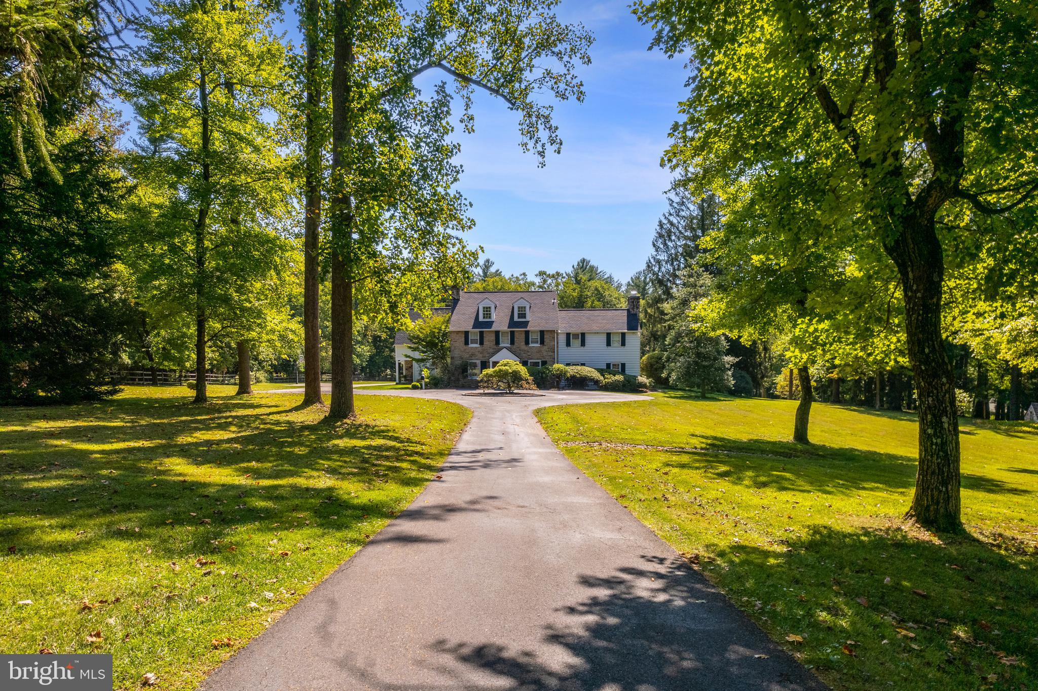 Presenting a private country retreat in the heart of Whitemarsh Township. Surrounded by large estates, and open space, including nearby Highlands and Fort Washington State Park, this 5 bedroom, 4 full and 2 half bath showstopper blends the best of traditional and Aspen-style architecture with state-of-the-art modern conveniences. Extraordinary quality and craftsmanship are showcased in the custom wood trusses, 2-story stone fireplace, custom cabinetry, granite counters, barn-wood doors, and more. The heart of this entertainer’s paradise is the sun-filled 2-story great room, with custom wood trusses, large sliding barn door, iron railings, custom chandelier and grand, 2-story stone fireplace, flanked by French doors that open to the rear grounds. The large, open chef’s kitchen features an expansive center island and leathered granite counters, farmhouse sink, Thermador 6-burner range with pot filler and stone surround, double Thermador ovens, Miele coffee station with beverage fridge, and walk-in pantry. An open dining area and large, custom-hewn bar area with beverage fridge and ample cabinetry make the open first floor concept an entertainer’s dream. Numerous sets of French doors step out to the slate terrace, with built-in firepit and large covered area with built-in BBQ, perfect for al fresco dining. The main floor also includes a cozy den with fireplace, 2 powder rooms, living room, and large family entrance with mudroom, extra-large closet, and the first of two laundries. The primary bedroom suite features a large, open office area overlooking the great room, dual walk-in closets, and large bath with radiant floors and walk-in, stone-tiled shower. An expansive balcony overlooking the great room leads to 3 secondary bedrooms, one with ensuite bath, a full hall bath and the second floor laundry room. The third floor offers the fifth bedroom, walk-in closet and full bath. The lower level offers a large, unfinished bonus space and ample storage. An oversized, 3-car garage and separate, 1 bedroom cottage with 2 additional garage bays completes this fantastic property. Set in a superlative location with easy access to local shops and dining, major roads, Flourtown and Chestnut Hill.