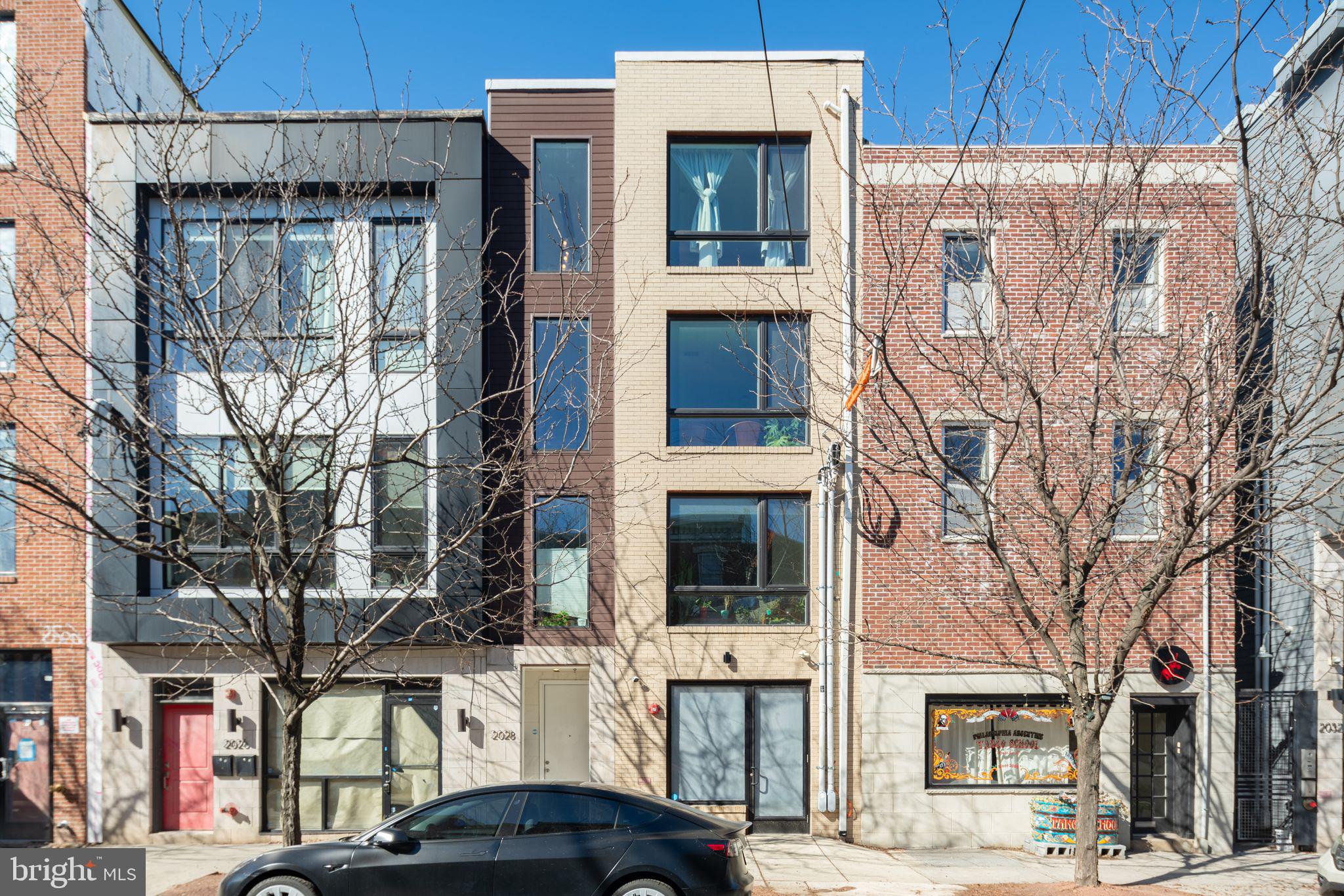 This beautifully designed bi-level residence offers spacious living, private outdoor space, and an incredibly walkable Fishtown location. Situated on the top two floors of a quiet boutique condominium building, the first floor of this layout offers generously proportioned open dining and living, with soaring ceilings, sunsplashed with a wall of east facing windows, warmly accented with natural wood. A custom wall sculpture and pendant chandelier complete this unparalleled living space, which easily accommodates large furniture in a number of configurations, as well as a work from home space if desired. Modern chef's kitchen features quartz countertops, gas cooking and a full suite of stainless steel appliances, soft gray subway tile backsplash which accents the two toned kitchen cabinetry and island with ample prep space and counter seating for casual dining as well as entertaining with ease. A convenient powder room completes the first floor. Take the stairs up to your second level, which has two well proportioned bedrooms, each with an en suite full bath. Primary bedroom features a huge walk-in closet. First full bath has a bathtub and sliding glass shower enclosure. Second full bath off the primary bedroom has dual sinks and an oversized walk in shower, designed to feel like an at home spa. This level also features a separate laundry room, and a wet bar that could also function as a coffee station or extra utility sink and space. On the top level is your own private roof deck, offering nearly 360 degree city views with gracious space for furniture, and an all new deck and rubberized tile floor for comfort and enjoying the warmer months. Find all that Fishtown has to offer just steps outside your door - your coffee from Cake and Joe just a couple doors downstairs, boutique shopping on your corner, snag a seat at top rated Yuhiro sushi and omakase around the corner, your groceries from Riverwards Market less than two blocks, and coveted reservations at local hotspots like Kalaya, Suraya, LMNO, and so many more just steps from your front door. The Berks Street station of the Market Frankford line is just 0.4 miles away, for a quick commute downtown to Center City. Enjoy the benefit of low taxes, with approximately 4 years remaining on the 10 year full tax abatement for this property. Truly a must see residence for a discerning client looking for a perfect city home.