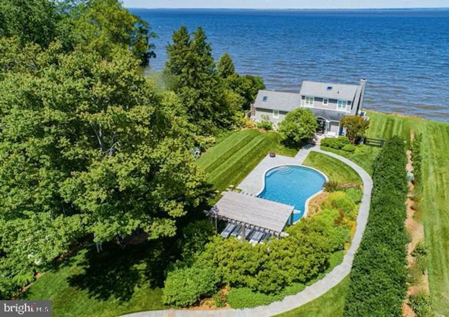 Built on a 40-foot bluff overlooking the Chesapeake Bay facing west for nightly sunsets, this is a tour-de-force of design and luxury on the Eastern Shore of Maryland, with truly stunning views from every room. Follow your dreams with this resort-like property as a primary or secondary home. Drive along the maple-lined lighted drive to 1.5 acres of award-winning, irrigated, landscaped grounds designed by South Fork Studio. Walk through the mahogany gate into the courtyard with fountain along the bluestone path around the Gunite pool. The main house on the water (c. 2011 and updated in 2018) has 3 bedrooms and 2 and 1/2 baths, and a wall of large windows with an automatic shade system that follows the sun's path. Open floor plan living with private first-floor owner's suite (double shower, Toto washlet, and custom walk-in closet). Wake up to views of the Bay and Bald Eagles fishing. Custom hand-crafted hardwood flooring, millwork, cabinetry, and New Zealand wool carpeting. Built-in Sub-Zero and Wolf appliances and top-of-the line luxury materials throughout. Automated control for whole-home media and sound, lighting, HVAC, irrigation, swimming pool, alarm system, and window shades. Gas-started wood-burning fireplace in the living room. Ipe decking, 3 outdoor showers, and numerous spaces to entertain friends and family. A custom-lighted staircase and brand-new dock (2023) with boat lift and large Ipe dining table sit above the rip-wrapped shoreline. 
The guest house and three-car garage, designed by Purple Cherry Architects and built by the acclaimed Taylor-Loughry partnership in 2019, cleverly create the privacy, mystery and architectural stature of the entire four-parcel domain. Currently, the guest house presents 1 bedroom, 1 full bathroom with laundry, a kitchenette and a very large multi-purpose room with cathedral ceiling that overlooks the center core of the gardens, saltwater and heated pool, custom cedar pergola, and Chesapeake Bay.
The pool building contains the latest technology in pool filtration, whole-property water filtration system, well pump, irrigation system, pool heater, and storage. There is also on-demand hot water throughout the property and radiant heated flooring in all full bathrooms.
This property awaits a most discerning and capable buyer yearning for a discreet and well-designed lifestyle. Only 15 minutes from historic downtown Chestertown.