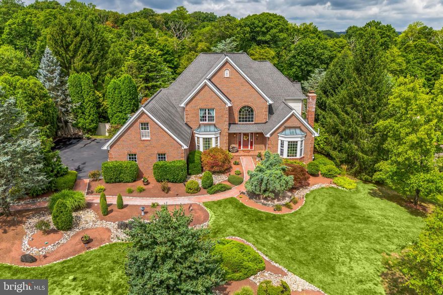 Nestled in picturesque Wrightstown Township and within the esteemed Council Rock School District, this magnificent residence on 1.27 acres offers a blend of elegance and tranquility. As you approach, the meticulously manicured landscaping and charming brick paver walkway set a welcoming tone, reflecting the home's exceptional upkeep. Step inside to the grandeur of a two-story foyer, where moldings and wainscoting provide a touch of sophistication. The living room, filled with natural light from ample windows, boasts a cozy fireplace, rich hardwood floors, and tray ceiling adorned with intricate moldings. Built-in curios add a unique charm, while the adjacent study, with its crown molding, French doors and recessed lighting, offers a quiet space for reflection or work. Entertaining is a delight in the formal dining room, where tray ceilings and elegant wainscoting create an inviting atmosphere for gatherings. The kitchen, the bright and spacious heart of the home, features an abundance of cabinetry and a functional center island, making meal prep a joy. The adjoining sunroom bathed in sunlight, provides a perfect spot for morning coffee or relaxing, with views of the lush backyard. The family room, with its soaring two-story ceiling and warm wood pellet stove, invites cozy evenings. Sunroom glass door opens to an expansive deck, ideal for outdoor dining and summer barbecues. The primary bedroom, conveniently located on the first floor, is a private sanctuary with coffered ceiling and an en-suite bathroom. Recently remodeled, the master bathroom exudes luxury with a freestanding tub, double vanity, and a built-in makeup vanity. There is radiant floor heating that extends into the floor of the door free shower enclosure. The upper-level hosts three spacious, well-appointed bedrooms, each with a private en-suite bathroom featuring jetted tubs. Additional 'secret' bonus rooms offer versatility, whether for a home office, playroom, or extra storage. The walk-out/daylight basement is a true retreat, featuring a hot tub and sauna for ultimate relaxation. An exercise room, wet bar, and additional dining area make it a hub for entertaining. Outside, the backyard unfolds as a private oasis with a paver walkway leading to a sparkling pool, surrounded by a paver deck and complemented by a charming gazebo. The fully fenced yard provides a secure and serene environment, perfect for unwinding. There is a large shed in great condition tucked away at the back of the property. Some other items worth noting are that the entire rear of home was painted in 2022, new Sub-Zero refrigerator installed in 2021, new Bosch double oven installed in 2024, pool filter replaced 2023, automatic pool cleaner replaced in 2024, inside Jandy pool controller replaced 2024 and septic pump replaced April 2024. This home has been meticulously maintained, ensuring a seamless blend of luxury and comfort. With every detail thoughtfully considered, it offers a unique opportunity to live in one of the most desirable areas, close to nature yet conveniently located. Don't miss the chance to call this exquisite property your own.  Note: This residence boasts approximately 7763 sq ft of living space broken down as follows, 4736 above grade as per an appraisal, 2611 finished space in lower level, 416 sq ft of finished attic space over garage (secret rooms), which the appraiser did not count.