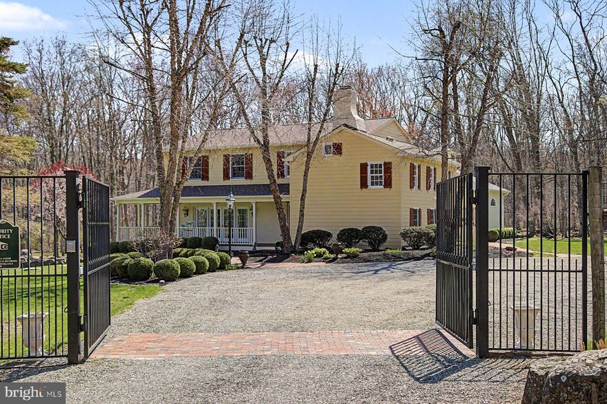 Make sure to watch the video...just click the video reel icon! Tucked behind a gated entrance and surrounded by 12.5 acres of lush, deer-fenced grounds, this enchanting Upper Bucks County property offers the rare opportunity to own a piece of history—beautifully reimagined for modern living. At its heart lies the original c.1700s log house, now transformed into a warm and inviting kitchen and dining space where exposed beams and timeworn textures create an unforgettable sense of place. This historic core is seamlessly complemented by thoughtful updates throughout, including three newly renovated bathrooms, refinished wood floors, and freshly painted interiors and exteriors. Designed for both everyday comfort and relaxed entertaining, the home features a gracious wraparound covered mahogany porch, a sun-drenched rear sunroom with radiant floor heat, and a flagstone patio that opens to sweeping lawns and curated landscaping. A first-floor bedroom provides flexibility for guests or single-level living. Upstairs, the primary bedroom offers a walk-in closet and updated en suite with heated tile floor and double vanity. The third bedroom and updated bath are down the hall. Beyond the main residence, a striking 3-car carriage house/garage adds both function and charm—ideal for collectors, hobbyists, or future creative use. Carriage-style bay doors have heated brick entry pads to facilitate access on snowy days. A long list of updates and upgrades offers peace of mind, including new roofs, new well tanks and water systems, bathrooms, new and refinished floors, electrical, lighting, new generator, and new window shades. Perfectly positioned just moments from Ringing Rocks County Park and a short drive to the Delaware River and its scenic Towpath, the property offers immediate access to hiking, cycling, and the natural beauty that defines the Upper Bucks lifestyle. Easton and the Lehigh Valley are 20 minutes away, and NYC is an easy 90 minute drive. Private, picturesque, and rich with character, this is a property that invites you to slow down, settle in, and stay awhile.