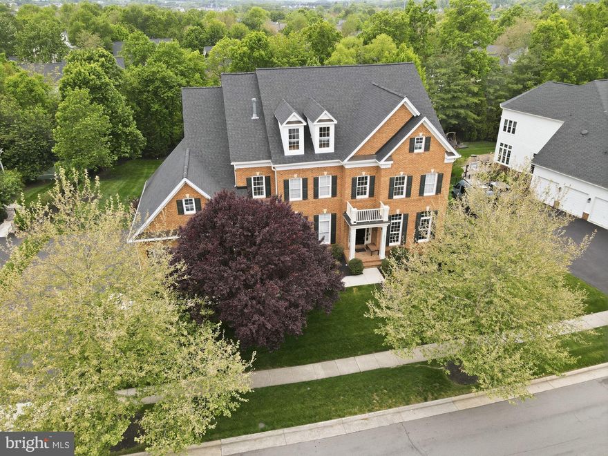 Welcome to an exceptional residence in the sought-after West Goose Creek section of Lansdowne on the Potomac, where space, thoughtful updates, and lifestyle come together seamlessly. Offering nearly 7,000 square feet of finished living space, this impressive home features five bedrooms, five full baths, and two half baths, all set behind a timeless red brick façade and complemented by an expansive, flat, fenced backyard with endless possibilities.  From the moment you arrive, the home’s curb appeal is enhanced by professional landscaping, in-ground irrigation, and elegant exterior lighting.
<br><br>
Enter the main level through an impressive two story foyer that immediately reveals the home’s scale and thoughtful design. Rich hardwood floors, updated designer lighting, and extensive crown molding extend throughout all three levels, while three fireplaces add warmth and character. The main level is both functional and refined, featuring a private home office, an elegant formal living room, and a banquet sized dining room ideal for hosting gatherings of any size. The formal living room is anchored by a two sided gas fireplace shared with the dining room, creating a natural connection between spaces. The kitchen flows seamlessly into the breakfast room and family room, offering an ideal layout for both everyday living and effortless entertaining.
<br><br>
At the heart of the home, the chef’s kitchen is designed for effortless gathering, featuring a spacious island with a prep sink, stainless steel refrigerator, an oversized pantry with a window, and a generous butler’s pantry. The adjacent family room creates a comfortable central hub and flows naturally outdoors to the composite deck, covered porch, and patio below—perfect for relaxing or entertaining on any scale.
<br><br>
Everyday functionality is just as well considered, with a large mudroom complete with built ins, offering the perfect drop zone for shoes, bags, and sports equipment, along with abundant storage throughout the home.
<br><br>
The upper level offers four spacious bedrooms, each with its own private bathroom, as well as a large, separate laundry room for added convenience. The primary suite is a true retreat, featuring a private sitting room, expansive walk in closets with custom built ins, and a beautifully updated bath with a seamless glass shower, dual vanities, granite countertops, and upgraded tile finishes.
<br><br>
The fully finished lower level expands the home’s versatility, offering a bright recreation room, a legal fifth bedroom, a full bath, and a dedicated gym space, making it ideal for guests, extended stays, or everyday living.
<br><br>
A spacious three car garage completes the home, featuring a professionally finished floor and a heavy duty StoreWALL organizational system with panels, shelving, hooks, and racks to keep everything neatly in place. Thoughtful updates include a 2021 roof, 2020 windows, and beautifully updated bathrooms in 2024.
<br><br>
Perfectly positioned for both convenience and lifestyle, the home is just moments from scenic trails and Goose Creek, within walking distance to multiple playgrounds and Winwood, and biking distance to two vibrant town centers. Residents of Lansdowne on the Potomac enjoy an unmatched amenity package, including a year round indoor pool, two outdoor pools, a 30,000 square foot community center, a fitness center with group classes, tennis and pickleball courts, game room, amphitheater with summer concerts, walking trails, parks, and a wide array of clubs and events.
<br><br>
This is a home that truly delivers on space, setting, and lifestyle—designed to be enjoyed at every level.