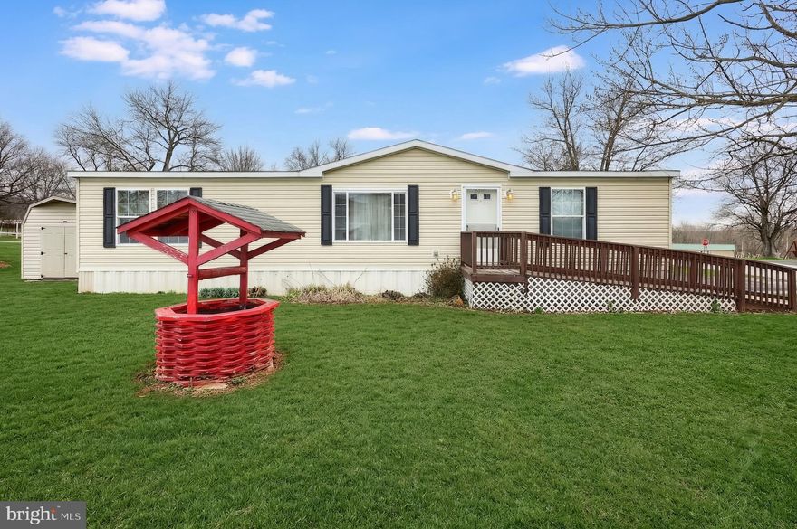 Enjoy easy, affordable one-floor living in this spacious 2010 double-wide offering over 1,400 sq. ft. of comfortable space. The living room features cathedral ceilings and a cozy wood-burning fireplace, creating a warm and inviting atmosphere.

The kitchen is well-appointed with upgraded cabinetry, ample counter space, and plenty of storage. All three bedrooms include walk-in closets, providing excellent storage throughout. A generously sized laundry room comes complete with a washer and dryer.

Lot rent is just $395 per month and includes water and sewer—an exceptional value. Conveniently located close to town while still offering a peaceful country setting.