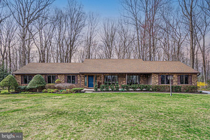 Welcome to the peaceful Stratton Woods community in Carroll County, where homes in this small neighborhood rarely become available. There is no yard sign as this is a private road, but potential buyers are welcome! This meticulous and lovingly maintained rancher sits on a flat wooded 3.11 acre property and boasts many custom amenities. The 600 sq ft TimberTech deck installed in 2021 looks out on a beautiful yard backing to trees. The front living room/dining room combo has beautiful bamboo flooring, a built-in buffet in the dining area and a custom home office suite that conveys with a desk, cabinets, bookshelves and filing cabinets. The unique gourmet kitchen next to the dining room has Amtico tile flooring, Silestone countertops and island, a floor to ceiling pantry and plenty of cabinetry with a beautiful view of the deck and backyard. The family room has bamboo flooring, a wood burning fireplace with heatilator for those chilly days and sliding glass doors to the deck and backyard. The large 15 x 14 primary bedroom suite has a ceiling fan and 4 casement windows, providing another awesome view of the backyard. The adjoining bathroom with sink, toilet & standup shower and the 15 x 11 dressing area were updated in 2024, which includes custom vanity, sink, soaking tub and skylight, and leads into 5 large closets for clothing and storage. Bedrooms 2 & 3 face the front of the house, each with their own closets and ceiling fans, and share a hall bathroom that was also updated in 2024.  The mudroom between the kitchen and garage has a full-sized washer & dryer, custom storage, leads to a convenient half bathroom, and has doors to the garage, deck and lower level. The lower level is partially finished, and the unfinished space can be used for storage and/or extra rooms, Bilco doors to the backyard, heat pump, whole house humidifier, wood burning stove that is tied into the house ductwork, water conditioning system, and bathroom rough-in. There is a finished 35 x 13 ft club/rec room with panel walls, carpet and drop ceiling. The 2-car garage also has a bay large enough for a riding mower and multiple built-in shelving units. All appliances convey. Walking distance to Liberty Reservoir, minutes to 70 & 695, and within the zone for excellent schools. Many appliances, AC/heat and other features are newer but too numerous to list – come see for yourself!