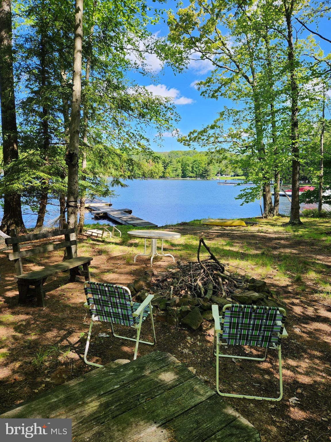 Experience the serenity and privacy of your very own parklike level lakefront --- own an unprecedented 180 feet of waterfront that's over an acre of lush wooded land all on the lake side of the road. Enjoy deep water with a Class A Dock Permit & physical dock with incredible sunset views. The ACRE PLUS WATERFRONT carries a conservation easement and can not be developed, so all the privacy is yours. Owner reports that the property is so secluded that you might choose private lakeside campfires or skinny dip under the moon. Your cozy rustic cabin awaits on an additional 1/2 + acre across the road from your lakefront land. It's a typical 60's with orange countertops and well used carpet, but good enough to use as you customize. You might choose to keep it a comfortable 3 bedroom size. Since there's public sewer though, you also have the freedom to go big, if you like. Enjoy being fully surrounded by huge rhododendrons and towering trees where deer and squirrels visit all throughout the day.