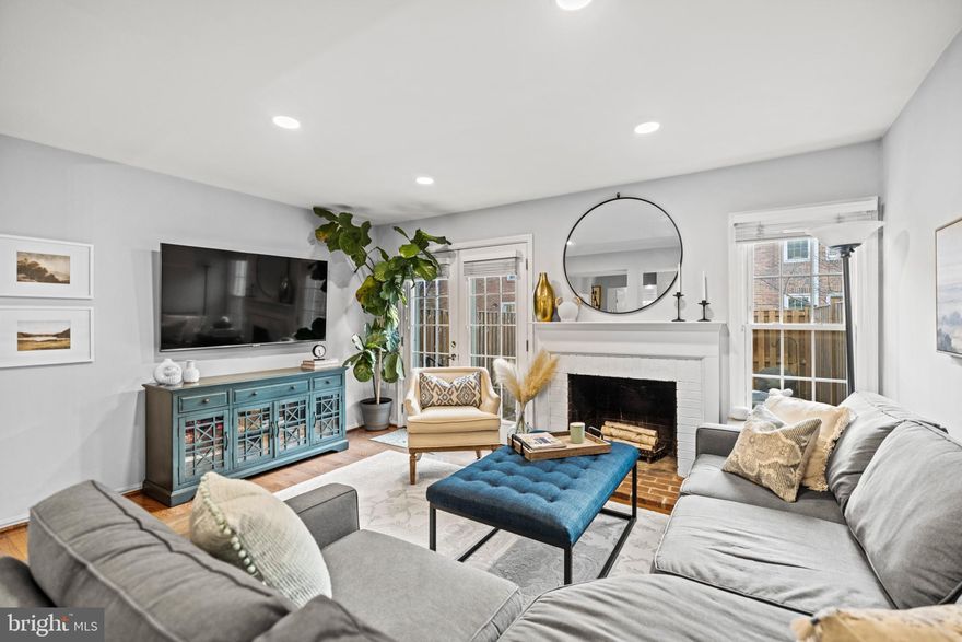 Welcome to this beautifully updated brick-front interior townhome in the sought-after Windgate community where thoughtful design and natural light fill every level of the home. As you enter, you’re greeted by a custom-built drop zone with wood paneling and coat hooks that offer both functionality and charm just inside the front door. From there, you’ll find the stunning newly renovated kitchen featuring crisp white cabinetry, white countertops, stainless steel appliances, a sleek herringbone-patterned backsplash, and a floor-to-ceiling window that brings in an abundance of natural light. The eat-in bar provides a perfect casual dining spot or place to gather while cooking. Just off the kitchen is the dining area, anchored by a statement light fixture that adds warmth and character to the space. The main living area features a wood-burning fireplace with brick surround, more floor-to-ceiling windows, and French doors that open to a fully fenced private backyard, ideal for entertaining, relaxing with a book, or enjoying your morning coffee. A powder room with an updated marble-top vanity completes the main level. Upstairs, the spacious primary suite is filled with natural light from tall windows and offers a serene retreat. A custom walk-through closet with built-in shelving and a sliding barn door provides both function and style. The primary bath features a marble-top vanity and a soaking tub that’s perfect for unwinding at the end of the day. The finished lower level offers flexibility with a third bedroom, a full bath, and an open space perfect for a rec room, office, or guest area to suit your lifestyle. Additional highlights include newly landscaped exterior, interior unit placement for added privacy, and a location just steps from the community pool and tennis courts. All of this just a few blocks from The Village at Shirlington, the Shirlington Dog Park, and Four Mile Run Trail, with plenty of dining, shopping, and outdoor recreation close by.