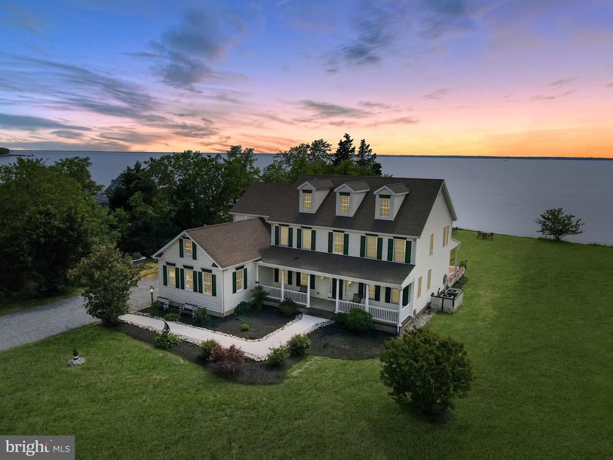 Welcome to 5520 Leeward Lane, a private waterfront estate tucked away at the end of a quiet, tree-lined drive on Tilghman Island—a rare opportunity to own a stunning piece of Maryland’s Eastern Shore. This expansive home features panoramic water views from almost every room and delivers the ultimate blend of luxury, comfort, and natural beauty. The grand foyer sets a graceful tone, leading into a spacious main-level layout designed to impress. The expansive living room is flooded with natural light and flanked by a formal dining area, a warm and inviting den, and a breakfast nook with vaulted ceilings—all connected by elegant sight lines and polished hardwoods. A true chef’s kitchen anchors the heart of the home, outfitted with a commercial-grade gas stove, a commercial refrigerator, two dishwashers, granite countertops, and an oversized island perfect for entertaining or casual morning coffee. The main-level primary suite is a private retreat, offering dual walk-in closets, a spa-inspired bath with soaking tub and glass shower, and serene views of the surrounding landscape. A conveniently placed laundry room with a half bath adds thoughtful utility to the main floor, while the upstairs offers flexibility with four generous bedrooms, a shared full bath, and a secondary living space complete with its own kitchenette—ideal for extended guests or multigenerational living. From nearly every room, you're drawn to the shimmering water just beyond the windows. Whether enjoying sunsets from the deck, stargazing from the rooftop deck above the three-car garage, or savoring peaceful mornings with the birdsong of the bay, this home embraces its setting with elegance and ease. Attic storage above the garage ensures ample space for seasonal gear or future creative use. Tilghman Island itself is a captivating enclave, celebrated for its maritime heritage, vibrant wildlife, and relaxed coastal vibe. Here, you’ll enjoy unmatched privacy, historic charm, and proximity to waterfront dining, boutique shops, and world-class boating—just far enough to escape, yet close enough to stay connected. 5520 Leeward Lane isn’t just a home—it’s a lifestyle. A sanctuary where land, sea, and sky converge in perfect harmony. Schedule your private showing and experience Eastern Shore living redefined.