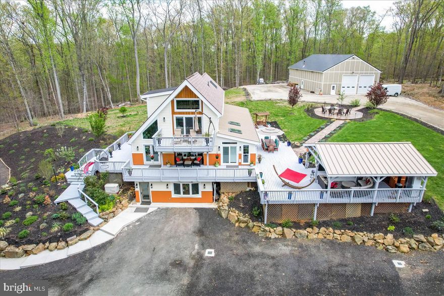 Welcome to "HARMONY ESTATE". Stunning 11.86 acres wooded, private compound minutes from downtown Leesburg.  No HOA. The estate has THREE separate buildings. Private, new, 12 feet wide asphalt driveway leads up to the the FIRST BUILDING. the main single family home. It has almost 4,000 sqft completely renovated finished interior, including a brand new addition, 3 LV, 4 BR, 2.5 BA. UL: huge owner's suite, solar powered and Bluetooth connected skylights. Primary BA: lux bath w/heated floors, soaking tub and shower. The primary suite also has a private living room that leads to the balcony. Main level: huge open kitchen with high-end appliances, double wall-oven, oversized island, granite counters, skylights, heated onyx floors, brand new sunroom & guest bedrooms addition. New 2,500 sqft wraparound deck accessible from every room on the main level. Lower level: large family room w/buit-ins, wince cellar, half bath and a huge laundry room/storage room. The lower level can be accessed directly from the exterior main front of the property and has an entry room, sitting room. The SECOND BUILDING: built in 2020 by FUOG Interbuild. 3000 sqft double insulated and temp controlled space, 16 ft ceiling heights, 3 doors; 12 ft wide, 16 ft tall, commercial built-in shelves. This building is currently used a shop but can be used for so many other business or event purposes: barn/event space/winery/art gallery/antique shop or car garage/camp, etc. The property zoned AR1! There is a stamped concrete walkway from the main house to the shop. The THIRD BUILDING: is a 1,000 sqft, insulated, heated space currently used as a 2-car garage and a gym, but it can be a 4-car garage or private offices or playroom. It was completely renovated in 2020: new commercial grade metal roof, new drywalls, exterior hardy plank and hardy panels. There is also a large gazebo by the main house with an 8 person jacuzzi, and an eclectic wooden sauna cabin. All 3 buildings has its own separate electrical meter. There is also a 500 gallons propane gas tank for the gas cooktop. Conveys also with the property a 22 KW Generac Bluetooth operated generator.