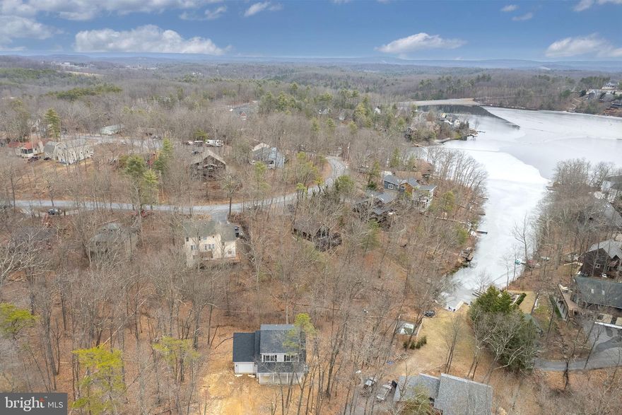 Low-maintenance new construction—no updates needed! Perfect for weekend lake living or simply downsizing to one-level! Welcome to Lake Holiday living—where everyday life feels like a getaway.
This brand-new 3-bedroom, 2-bath Cape Cod is perfectly situated on a quiet cul-de-sac in the gated Lake Holiday community, offering the rare opportunity to own new construction without the wait. Designed for both comfort and convenience, the home features a sought-after main-level primary suite with a walk-in closet, dual vanities, and a beautifully tiled walk-in shower. The open-concept main living area is filled with natural light and connects seamlessly to a well-appointed kitchen with granite countertops, shaker-style cabinetry, stainless steel appliances, and a center island—ideal for everyday living or entertaining. Upstairs, you’ll find two generously sized bedrooms and a full bath, providing flexible space for guests, family, or a home office. Enjoy your morning coffee or unwind in the evenings on the 26-foot covered front porch, taking in the peaceful, wooded surroundings. The full walkout basement with rough-in plumbing offers 800+ square feet of future living space—ready to finish to suit your needs. Located just 15 minutes from Winchester, Lake Holiday offers an unmatched lifestyle with private lake access, beaches, boat docks, clubhouse, fitness center, tennis courts, and more—all within a secure, gated community. If you’ve been considering new construction, this is your chance to skip the build time and move right in. Check out our 3-D tour and Lake Holiday video attached to this listing!