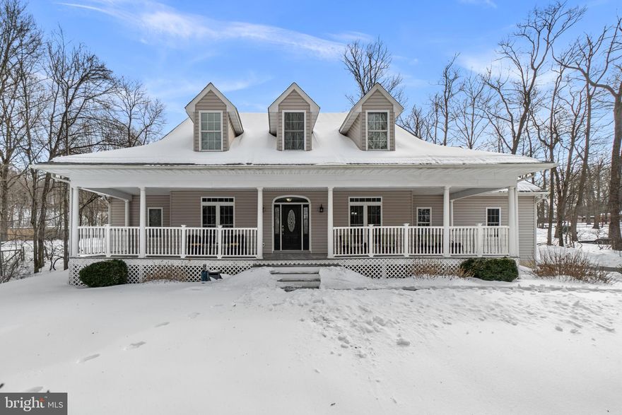 Set beyond a charming garden pond and a sweeping wraparound porch, this one-of-a-kind property sits on 1.69 acres of scenic beauty, where mornings start with views of nature and evenings unwind in privacy-- all just minutes from major commuter routes. Its the rare kind of home that feels like a peaceful escape without sacrificing everyday convenience. Step inside to a breathtaking grand foyer with a statement staircase that opens into a bright, airy two-story family room, creating a dramatic yet inviting space perfect for everyday living and entertaining. Fresh paint and gorgeous hardwoods are highlighted throughout the home, and every detail was thoughtfully considered. The main level features a dedicated office/library with built-in bookcases and French Doors for privacy. A formal dining room and a spacious gourmet, eat-in kitchen with a wet bar, island, and dining area are perfect for entertaining! The kitchen flows seamlessly into the stunning family room with vaulted ceilings and wood-burning fireplace. Off the kitchen, a powder room and laundry room/mudroom with sink and plenty of cabinetry round out the right wing of the home. A second powder room exists on the left wing of the home. Escape to the expansive main level primary suite-- a true retreat, offering a spa-inspired ensuite with a dual shower head steam shower, jetted soaking tub, dual vanities, and a large walk-in closet with organization system. Upstairs, youll find three spacious bedrooms, each with charming dormers, private ensuite bathrooms, and generous closet space, plus an expansive bonus room with a skylight and Palladian window-- a space ideal for recreation, gym, or a guest retreat. The open overlook to the family room adds architectural interest and connectivity throughout the home. The enormous basement with walk-up outside access is designed for entertaining and unforgettable evenings, featuring a wet bar with large island, a full bathroom, abundant storage, and the best part-- a one-of-a-kind hidden speakeasy concealed behind a bookcase. An unforgettable focal point! Step outside to a fully fenced backyard oasis, complete with a sprawling patio (partially covered), TV hookup, ceiling fans, and space to gather, relax, and entertain in total privacy. A shed tucked in the corner adds functionality while allowing the yard to remain open. This home is packed with premium upgrades and efficiencies, including: a new roof (2020), leaf filter gutter system (2024), whole-house generator, central vacuum system, SpacePak high-velocity A/C, water softener, and radiant heated floors with individual thermostats to customize temperature. With a 3-car oversized garage, 4 bedrooms, 5 full baths, 2 half baths, and thoughtful details at every turn, this property is a rare combination of luxury, privacy, and convenience-- where peaceful living meets everyday accessibility. Welcome home!