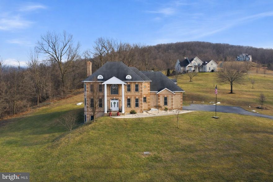 Stately all-brick colonial set on a private, elevated site with spectacular mountain views and million-dollar vistas stretching for miles. Surrounded by scenic countryside and positioned to capture breathtaking panoramic views of the surrounding mountains, this impressive residence sits on over three wooded acres in sought-after Boonsboro, offering exceptional privacy, timeless construction, and an unforgettable natural setting.

The home features a grand colonial layout with expansive, light-filled living spaces designed for both everyday living and entertaining, including a large eat-in kitchen ideal for gatherings and daily living. Two interior staircases add both character and convenience throughout the home. The designer primary bath has been completely remodeled with custom appointments, featuring heated floors, a clawfoot soaking tub, towel warmer, and a spacious walk-in shower. A laundry area on the main level with washer and dryer adds everyday practicality.

A finished walk-out lower level includes one bedroom and a full bathroom, providing flexible space for guests, recreation, or extended living.

Recent improvements and features include updated sensor lighting throughout the home, a water treatment system, stainless bath finishes, and clothing rod stops in closets.

Outdoor amenities enhance the property’s appeal, including two pergolas and a welcoming front porch, both perfectly positioned to take in the sweeping mountain scenery and peaceful surroundings. The property also includes a 24’ x 24’ detached garage with AC and electric, as well as a large barn with electric and a two-car garage component offering exceptional space for storage, hobbies, or workshop use.

This is a rare opportunity to own an all-brick colonial with extraordinary mountain views, extensive improvements, and outstanding privacy in one of Washington County’s most scenic locations.