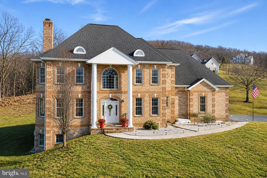 Stately all-brick colonial set on a private, elevated site with spectacular mountain views and million-dollar vistas stretching for miles. Surrounded by scenic countryside and positioned to capture breathtaking panoramic views of the surrounding mountains, this impressive residence sits on over three wooded acres in sought-after Boonsboro, offering exceptional privacy, timeless construction, and an unforgettable natural setting.

The home features a grand colonial layout with expansive, light-filled living spaces designed for both everyday living and entertaining, including a large eat-in kitchen ideal for gatherings and daily living. Two interior staircases add both character and convenience throughout the home. The designer primary bath has been completely remodeled with custom appointments, featuring heated floors, a clawfoot soaking tub, towel warmer, and a spacious walk-in shower. A laundry area on the main level with washer and dryer adds everyday practicality.

A finished walk-out lower level includes one bedroom and a full bathroom, providing flexible space for guests, recreation, or extended living.

Recent improvements and features include updated sensor lighting throughout the home, a water treatment system, stainless bath finishes, and clothing rod stops in closets.

Outdoor amenities enhance the property’s appeal, including two pergolas and a welcoming front porch, both perfectly positioned to take in the sweeping mountain scenery and peaceful surroundings. The property also includes a 24’ x 24’ detached garage with AC and electric, as well as a large barn with electric and a two-car garage component offering exceptional space for storage, hobbies, or workshop use.

This is a rare opportunity to own an all-brick colonial with extraordinary mountain views, extensive improvements, and outstanding privacy in one of Washington County’s most scenic locations.