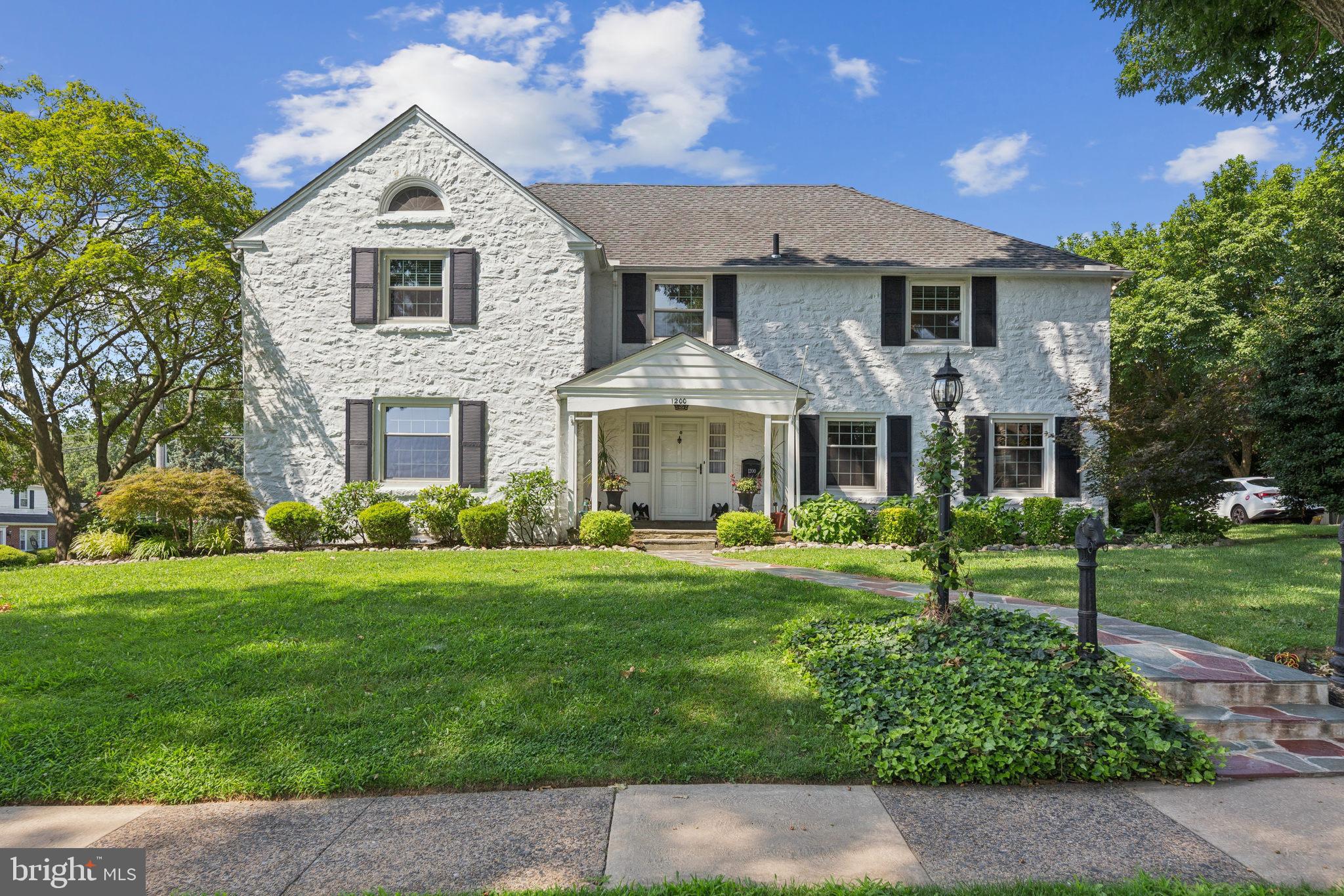 Step into timeless elegance and exceptional living in this one-of-a-kind 5-bedroom, 4 full and 2 half bath estate, gracefully positioned on a prominent corner lot in one of Drexel Hill’s most desirable neighborhoods. With over 4,300 square feet of beautifully finished living space — not including the expansive finished basement — this home has been thoughtfully transformed to blend classic charm with luxurious modern upgrades at every turn. From the moment you enter, you’re greeted by gleaming refinished hardwood floors, custom window treatments, and sun-filled formal spaces that flow effortlessly throughout the main level. The living room, anchored by a gas fireplace converted in 2017 and serviced annually, offers a warm and elegant setting for quiet evenings or lively conversation. Just across the hallway, the formal dining room offers the perfect backdrop for holidays and dinner parties, framed by timeless detail and bathed in natural light. The kitchen is the showpiece of the home — a true chef’s dream with granite countertops, stainless steel appliances, radiant heated floors, and a large center island with built-in wine rack. It opens seamlessly to a spacious, sunlit family room where sliding glass doors lead to an outdoor living area beyond compare. The backyard patio, fully redesigned by Plymouth Nursery, offers a private retreat ideal for entertaining or unwinding in complete comfort. Just off the family room, a dedicated home office with brand-new carpet offers the perfect work-from-home space. A first-floor laundry room and stylish powder room round out the main level with both elegance and convenience. Upstairs, the primary suite is a tranquil escape with its own gas fireplace, custom shades, and a full bathroom. Down the hall, the fourth bedroom features a sleek, updated full bath — perfect for overnight guests or multigenerational living. Two additional spacious bedrooms offer flexibility for family, guests, or creative use, all with custom blinds installed in 2024. On the third floor, a fifth bedroom with its own full bathroom is accompanied by a large walk-in storage room, ideal for seasonal items or bonus living space. The finished basement expands the home’s livability even further, offering a half bathroom, a utility room, and a versatile space just off the garage entry — designed like a mudroom with a large closet, perfect for coats, bags, sports gear, or everyday essentials. This practical yet stylish area provides direct access to the oversized two-car garage and completes the home with a sense of ease and organization rarely found.
Every inch of this home reflects pride of ownership and high-quality upgrades. In 2024, a full perimeter drainage system was installed along the side and rear of the home, along with French drains and a sump pump in the furnace room. That same year, the chimney received a new crown, flashing, and exterior covering. A Leaf Filter gutter system has been added for low-maintenance living, and custom motorized shades were installed in the kitchen, office, and family room. Mini-split heating and cooling units in the living room and primary bedroom provide year-round comfort. The driveway was redone in 2023, adding to the home’s polished curb appeal and functionality. Located just minutes from Dermond Field, local parks, shopping, dining, and with easy access to Center City and major commuter routes, this home offers the rare combination of space, luxury, and location in one of Drexel Hill’s most beloved neighborhoods. It’s more than a home — it’s a lasting statement of comfort, quality, and refined living.
