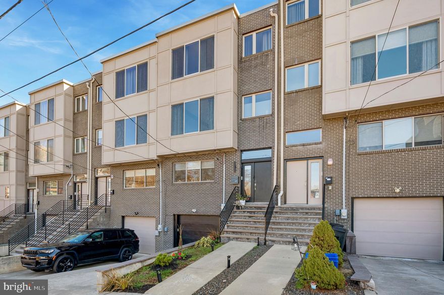 Don’t miss this exceptional 4- bedroom, 3 full bathroom townhome tucked away on a quiet street in the heart of highly desirable Manayunk, offering easy parking and modern construction. This home features a thoughtfully designed open floor plan with contemporary finishes, abundant natural light, and spacious living across multiple levels.
The main living level showcases engineered hardwood flooring, high 9 ft ceilings, recessed lighting, and sleek modern design throughout. The bright and airy living room flows seamlessly into the dining area and chef’s kitchen, creating the perfect space for both entertaining and everyday living.
The kitchen features stainless steel appliances, gas cooking, Carrara tile backsplash, white quartz countertops, modern cabinetry, and generous storage. A large center island, with unique pendant lighting and breakfast bar seating, provides additional prep space and casual dining for 3–4. Oversized windows and sliding glass doors fill the space with natural light and lead to a composite rear deck with steps down to a fenced yard, ideal for outdoor relaxation.

Upstairs, three generously sized bedrooms offer comfort and flexibility. The second level has two additional bedrooms that share a hall bath, with a tub/ shower combo. A convenient second-floor laundry room includes the washer, dryer, and one of two high-efficiency HVAC systems.
You will be wowed by the entire third-floor level, Besides being dedicated to the expansive primary suite, creating a true private retreat. This level is filled with light from top to bottom. This luxurious space includes two walk-in closets and a spa-inspired en-suite bathroom with a large glass-enclosed shower. The level also features a beverage station, perfect for a coffee bar or entertaining before stepping out to the nearby rooftop deck.
The spacious rooftop deck offers stunning sunset views and an incredible space for entertaining, relaxing, or enjoying the skyline.
The lower level provides incredible flexibility with a fourth bedroom or home gym, a third full bathroom, and inside access to the attached one-car garage. A private driveway provides parking for a second vehicle, and an additional nearby public lot offers convenient guest parking. The garage is equipped with an EV universal charging port.
Perfectly located near major highways, public transportation, and the Schuylkill River Trail, this home allows you to easily enjoy outdoor recreation while being just minutes from the vibrant shops, restaurants, and nightlife of Main Street Manayunk.
This stunning home perfectly blends modern city living with neighborhood charm.