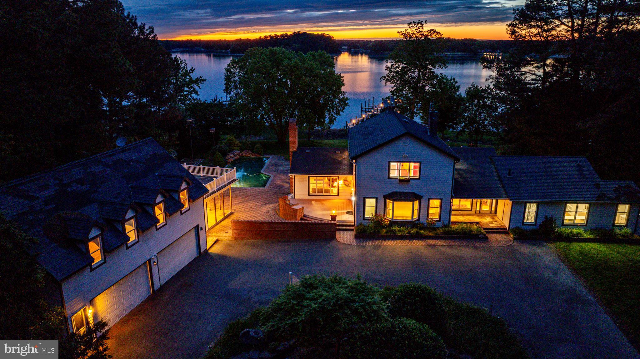 Waterfront living on the Tred Avon River with water views from nearly every room. This spacious home sits on 3.2± acres and is introduced by a gorgeous circular drive. Enjoy waking to colorful sunrises from either the main-level primary suite with access to the back deck or the second-floor primary suite with its own balcony. The gourmet kitchen flows seamlessly into the main living areas and out to a large waterside deck—perfect for entertaining. Enjoy the waterside saltwater pool with stone waterfall, surrounded by landscaped grounds. A detached climate controlled garage offers a second-level guest suite or recreation room with its own balcony, along with a convenient poolside kitchenette and bathroom. Boat lift and kayak/canoe lift and multiple slips can be found on the private pier with approximately 5' MLW. Conveniently located on Rt 33 this residence is a short distance to Easton's amenities and Rt 50 or St Michaels shops, restaurants and more.